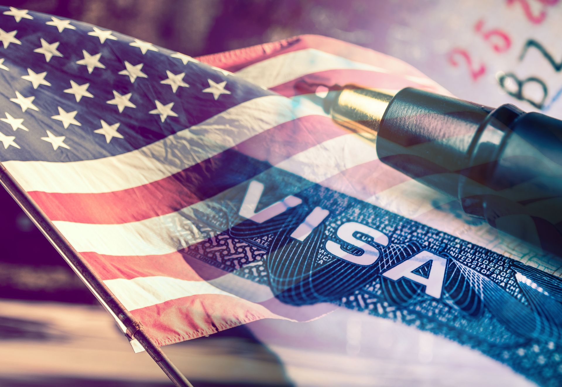 A pen is sitting on top of a visa next to an american flag.