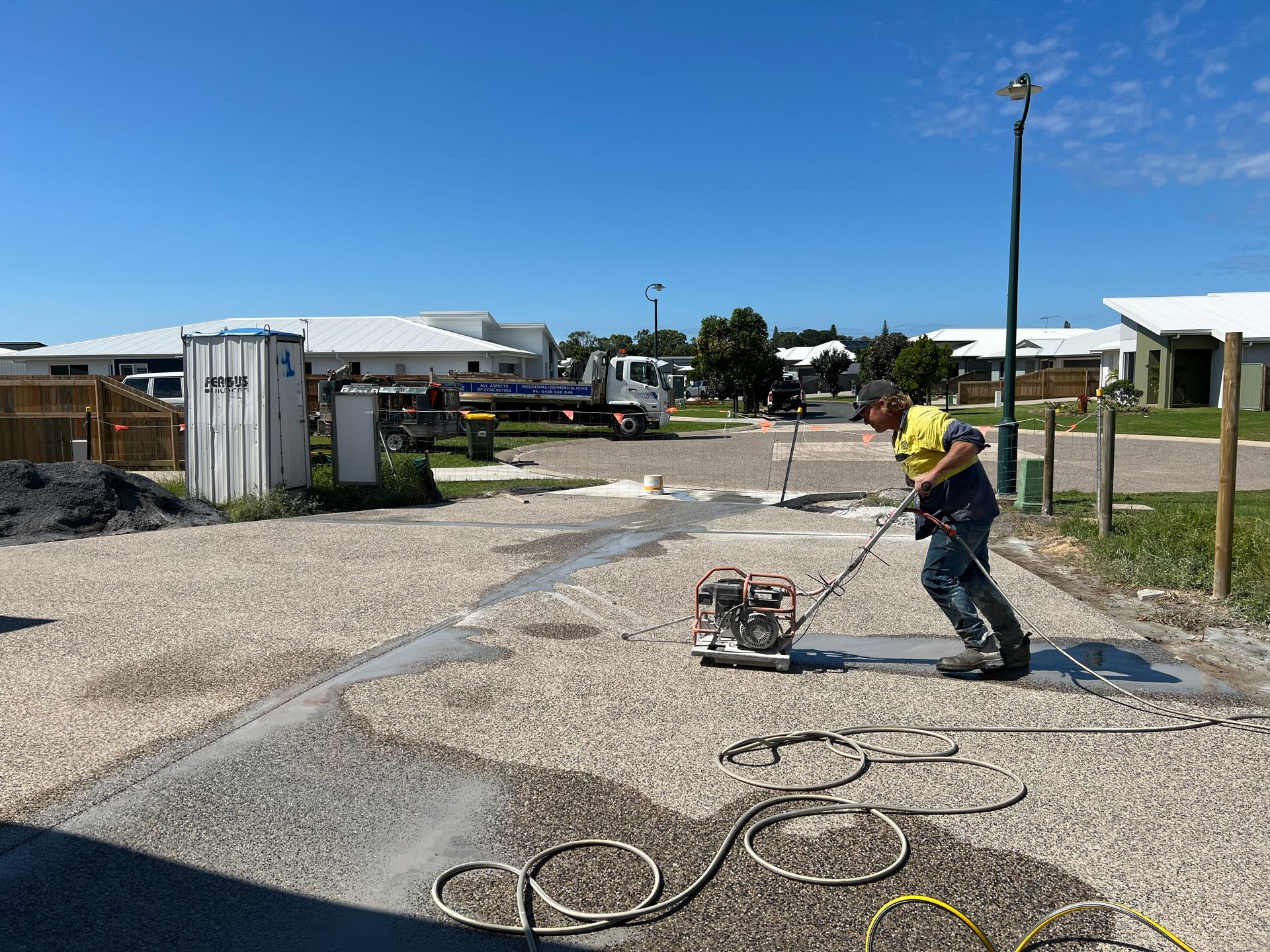 Construction worker using a power grinder on a gravel driveway — Ablecut Concrete Cutting & Coring In East Mackay, QLD