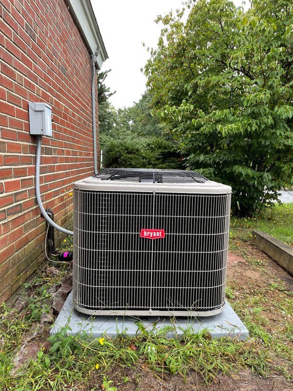 Outdoor Bryant air conditioning unit next to a brick building.