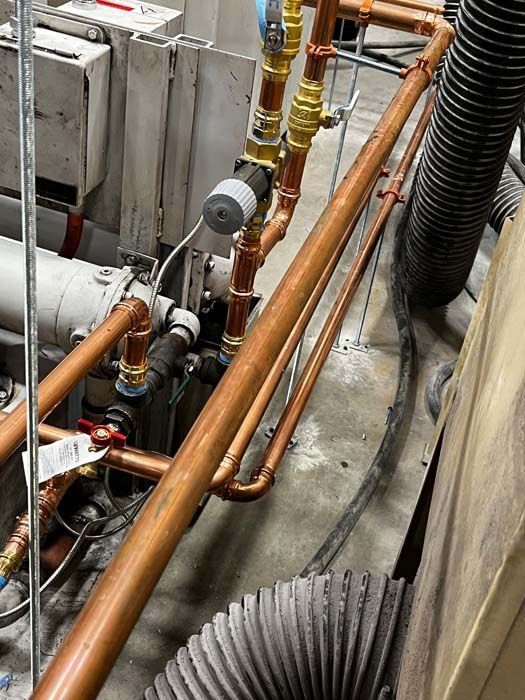 Copper pipes and valves in an industrial setting.