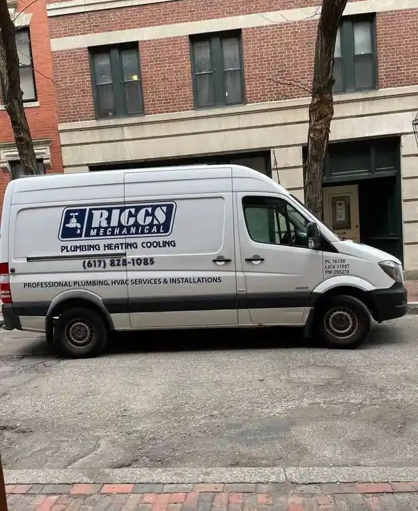 White Riggs Mechanical van parked on a city street, advertising plumbing, heating, and cooling services.