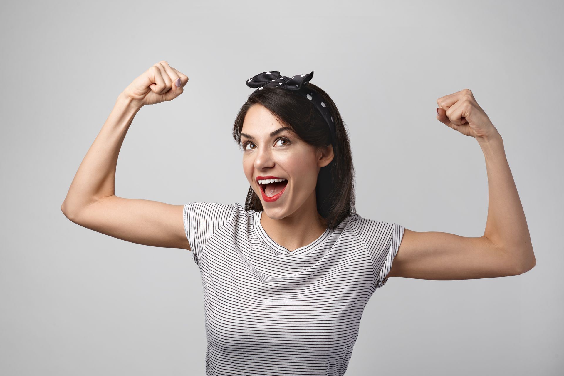 A woman in a zebra print shirt is flexing her muscles.