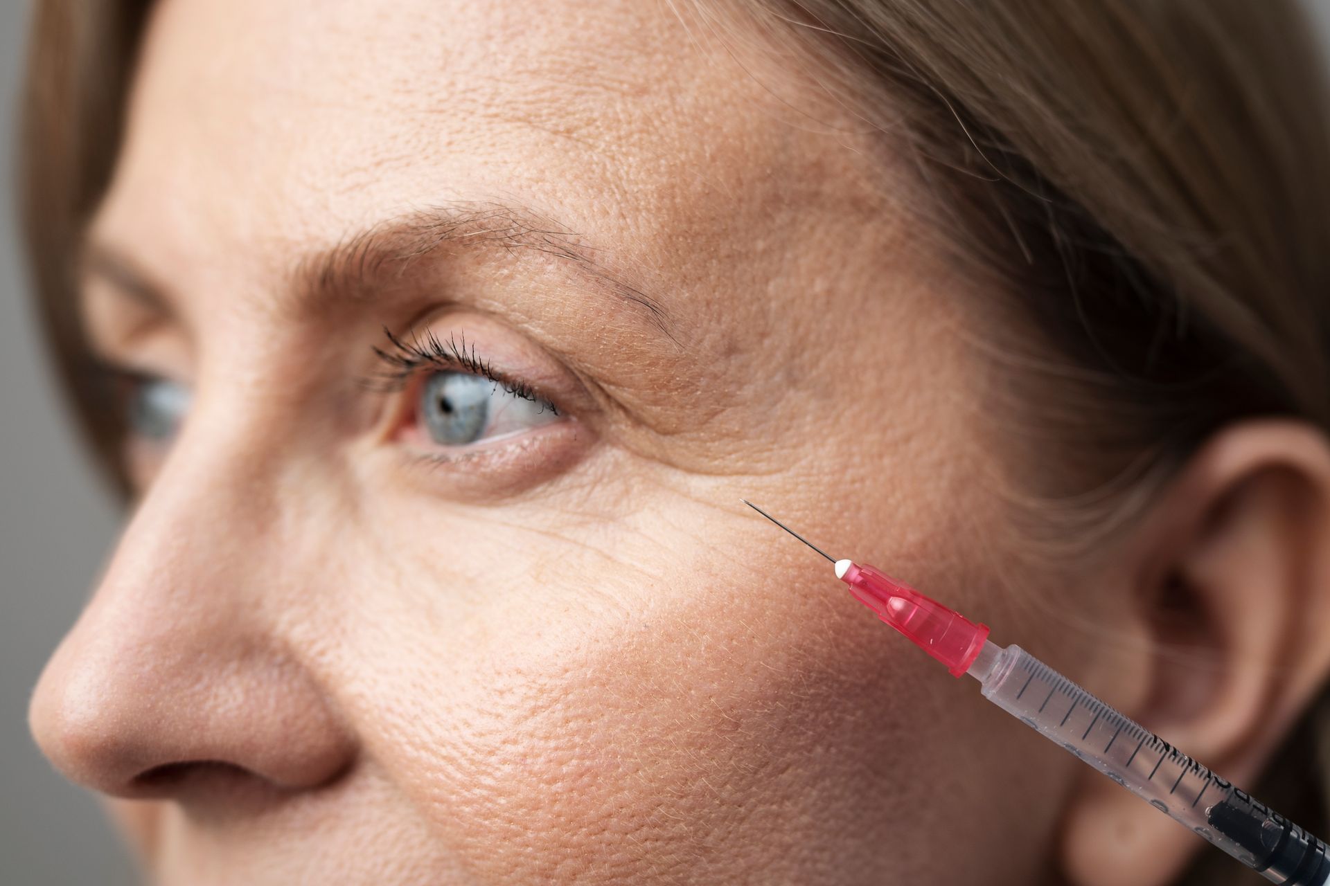 A woman is getting an injection in her eye.