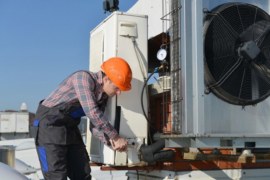 expert repairing an AC outdoor unit