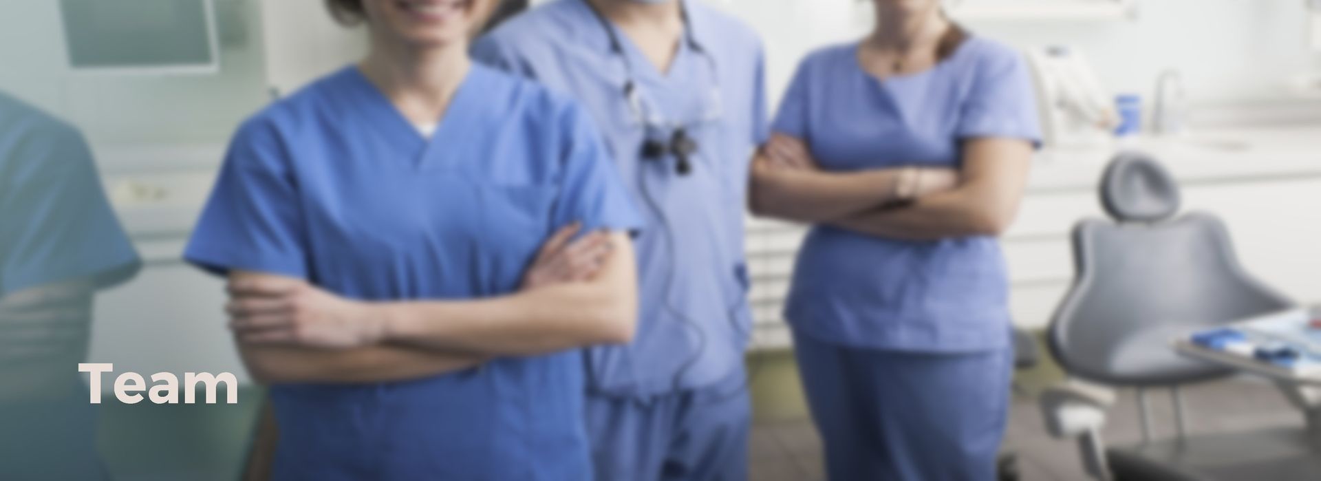 Eine Gruppe von Zahnärzten steht mit verschränkten Armen nebeneinander in einer Zahnarztpraxis.