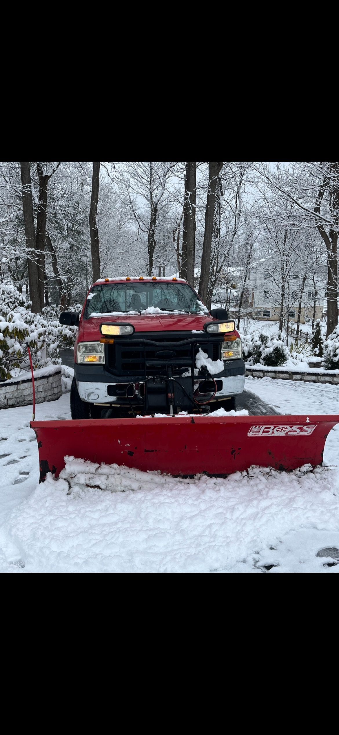 A snow plow is clearing snow from a snow covered road