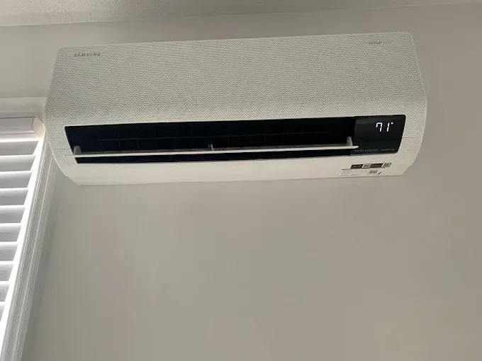 White wall-mounted air conditioner unit showing a temperature display of 71 degrees.