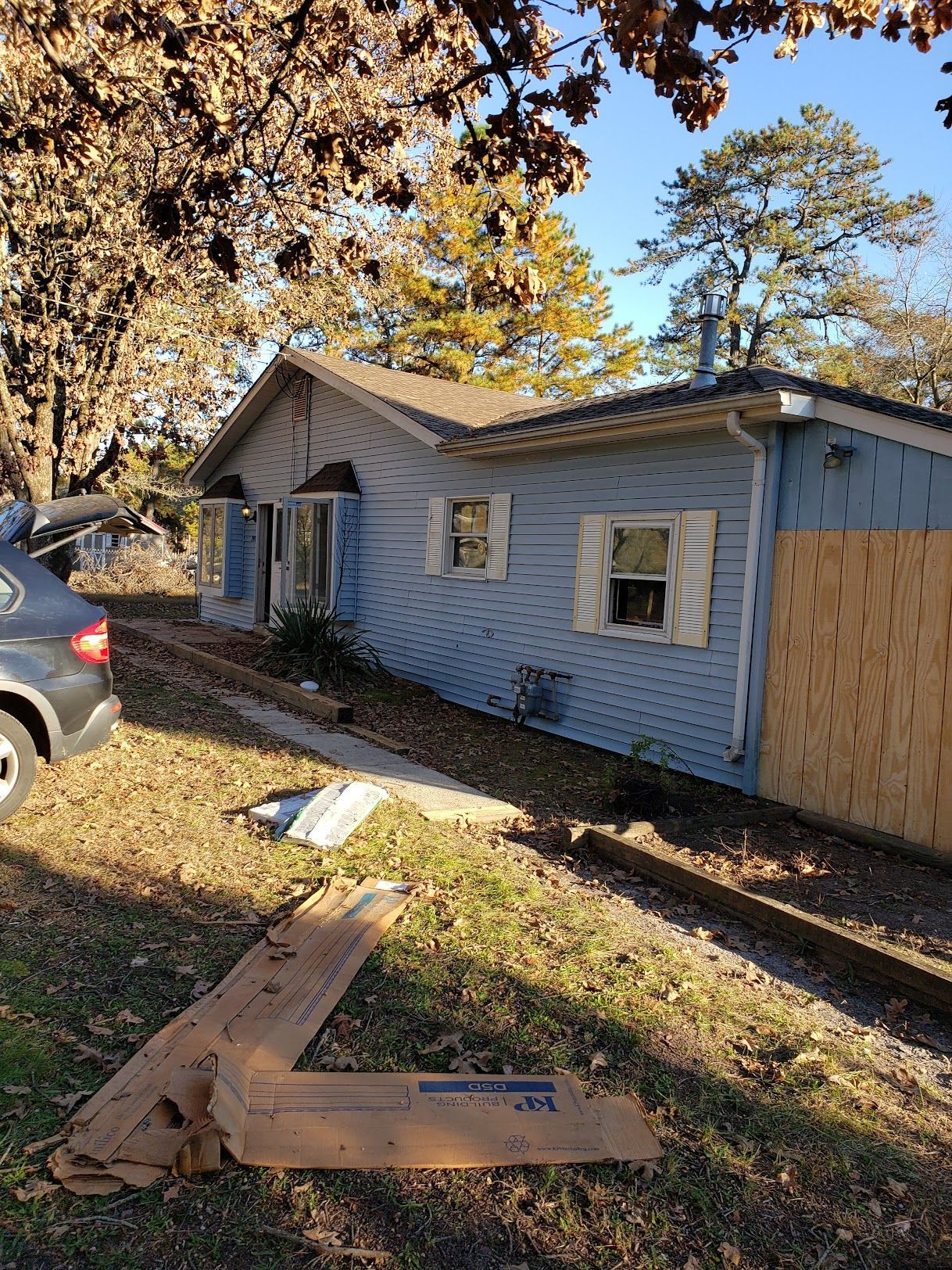 A blue house with a car parked in front of it.
