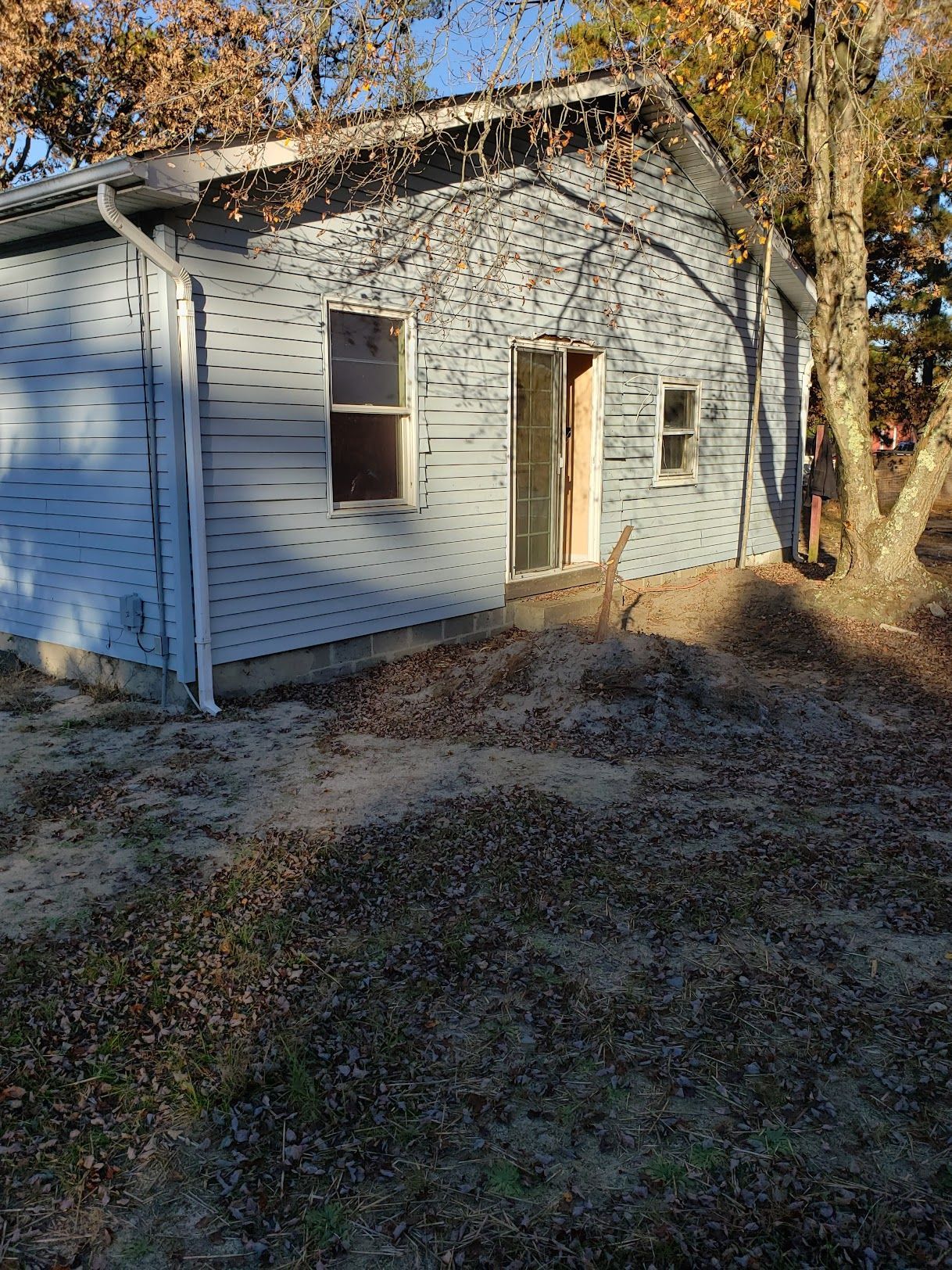 A man is standing in front of a small house.