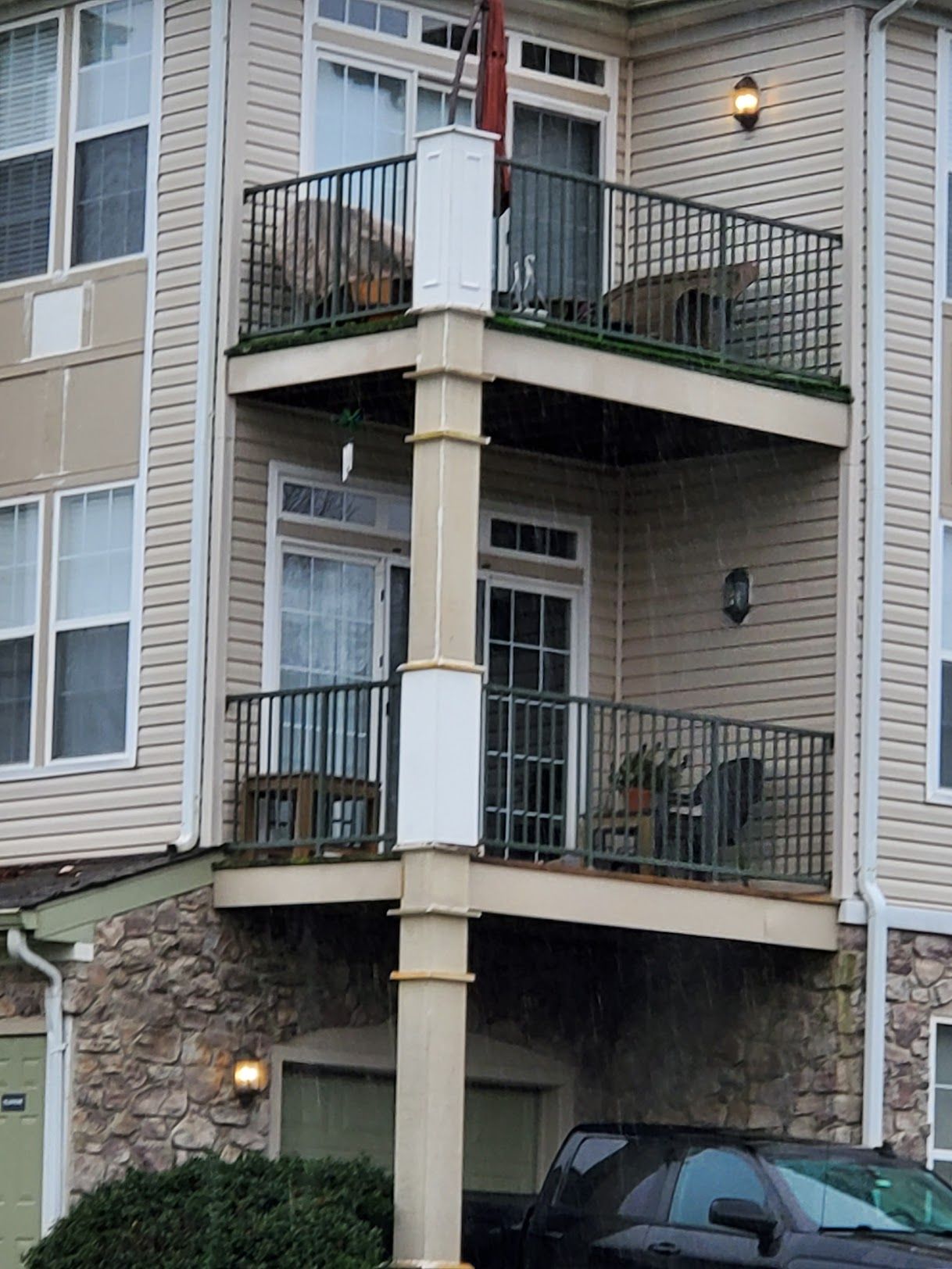 A car is parked in front of a house with a balcony