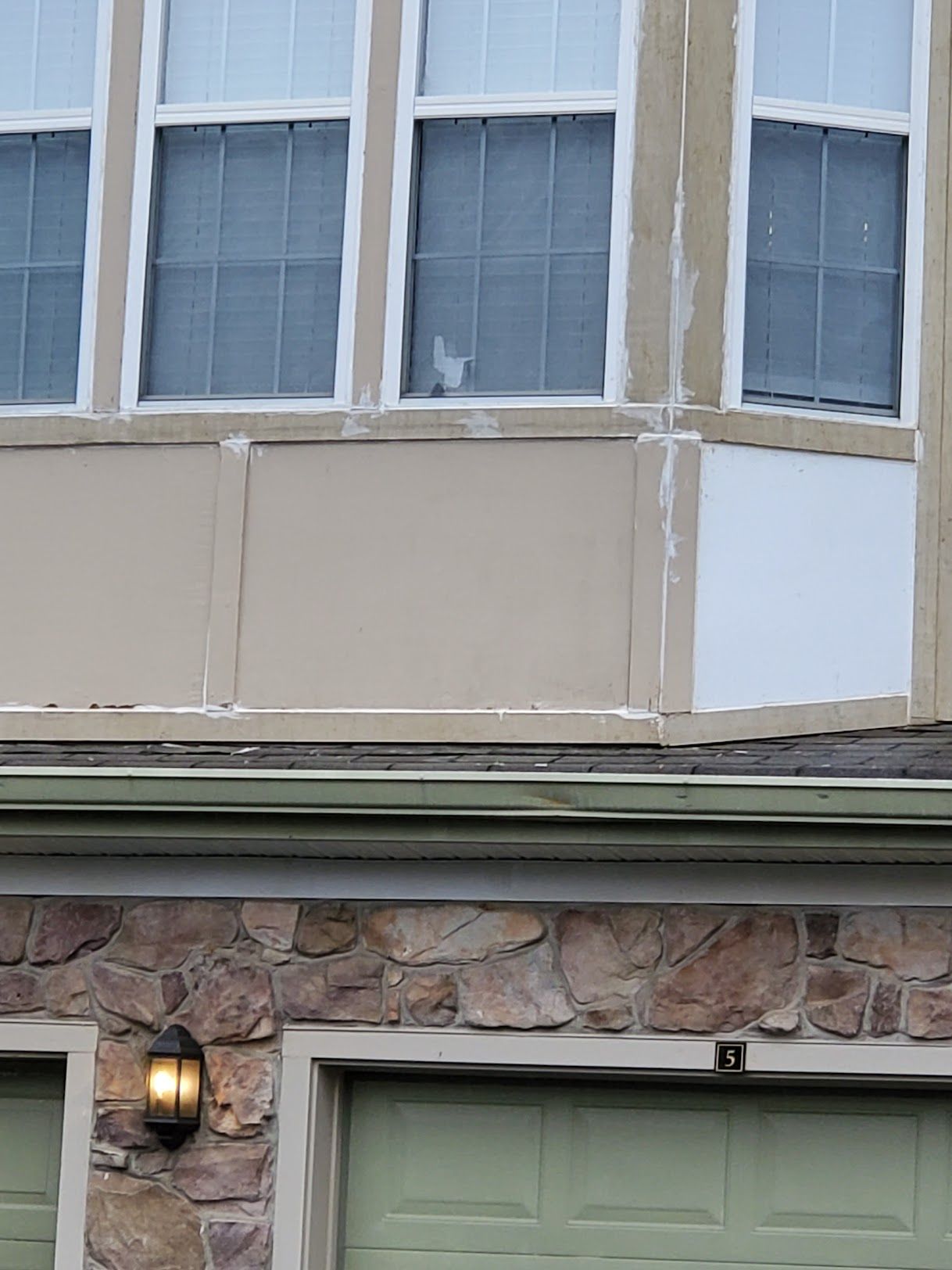 A cat is looking out of a window of a house.
