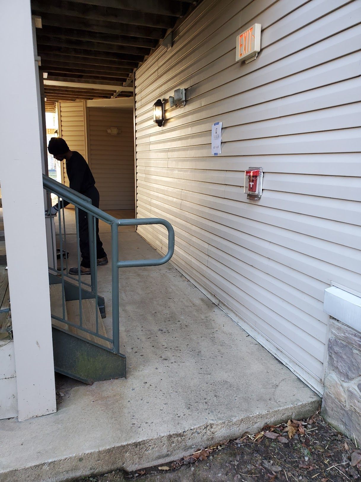 A man standing next to a staircase next to a fire extinguisher