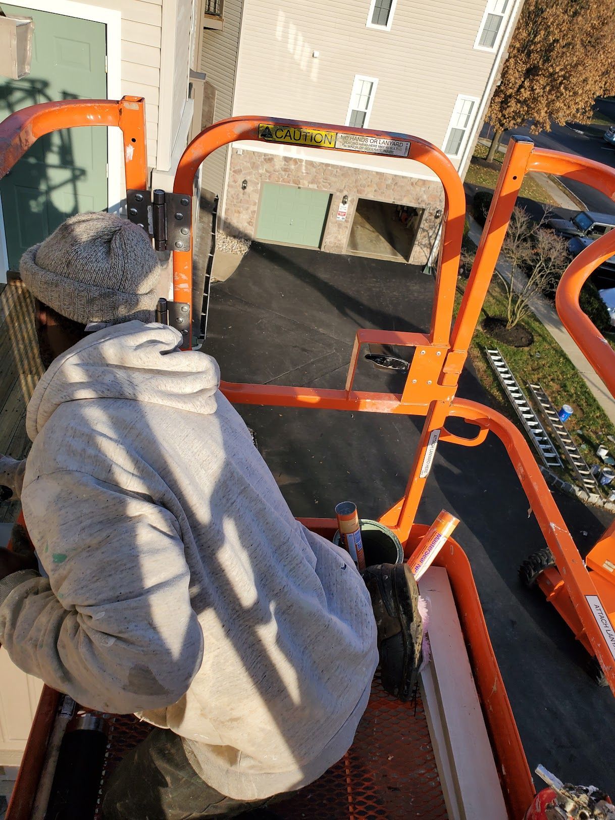 A man is sitting on a crane looking down at a building.