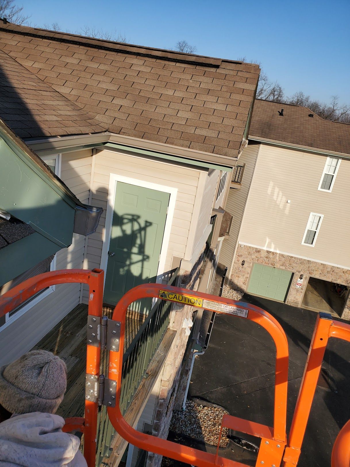 A man is standing on a ladder in front of a house.