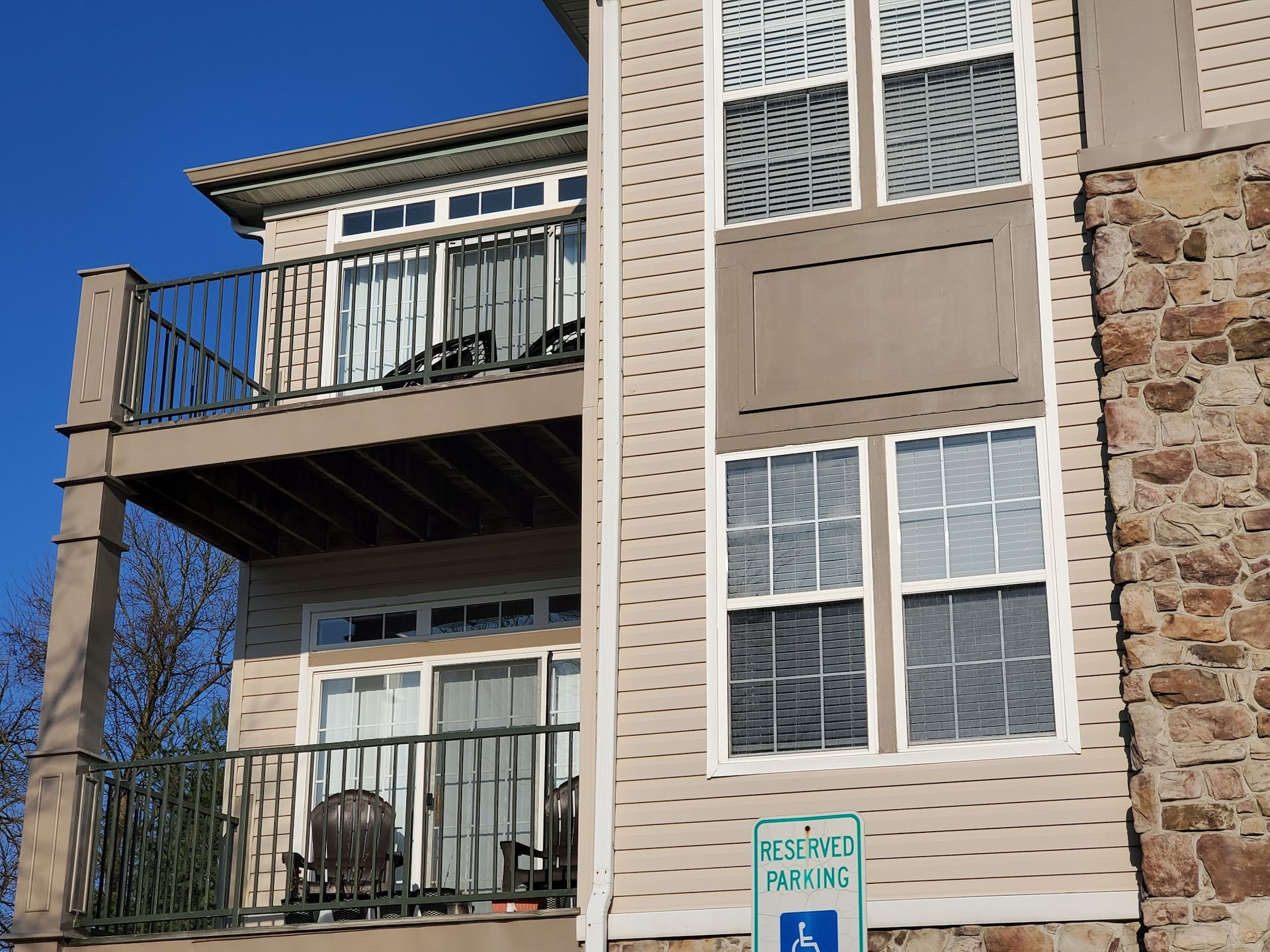 A handicapped parking sign is on the side of a building