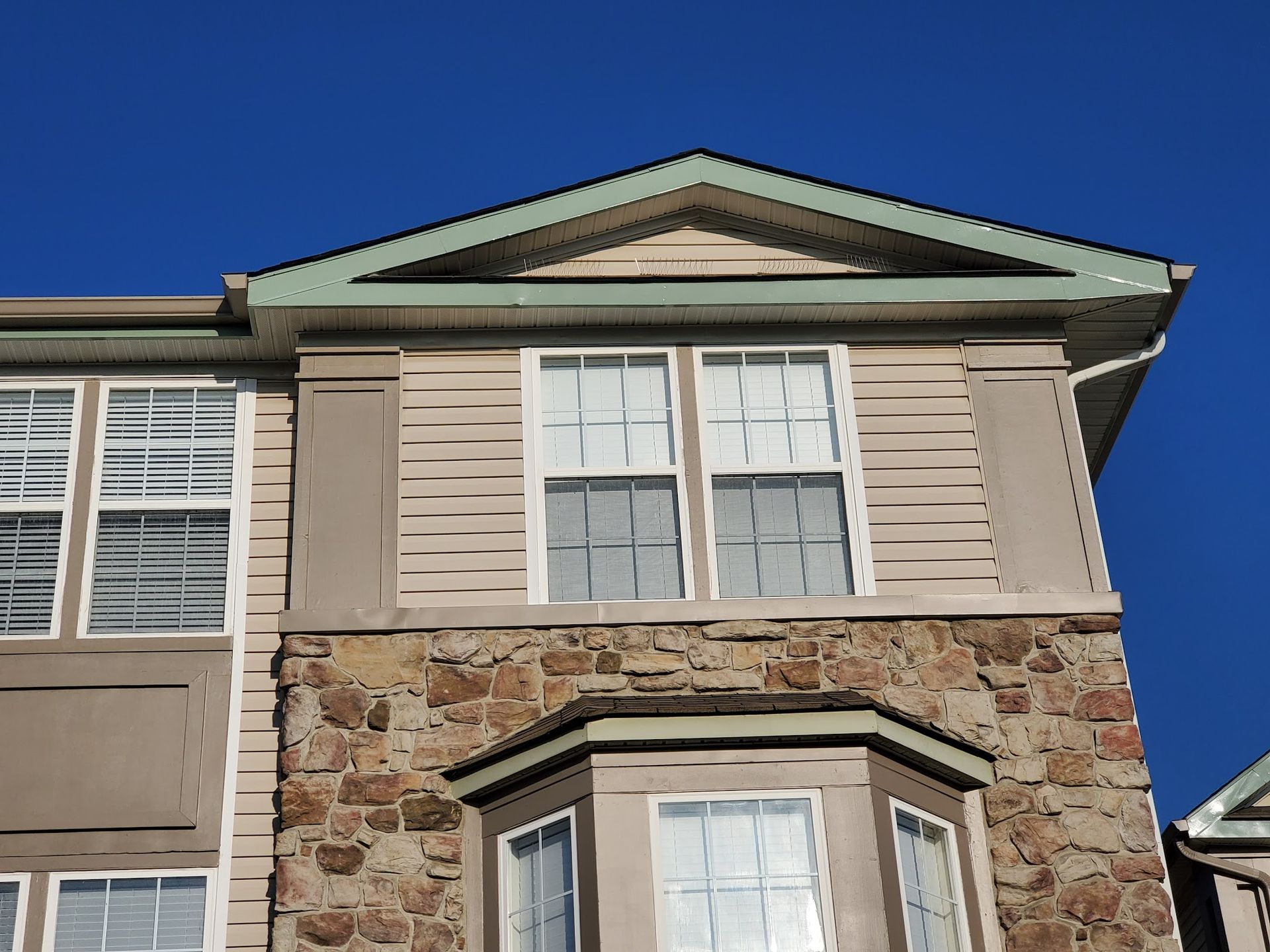 A house with a lot of windows and a blue sky in the background