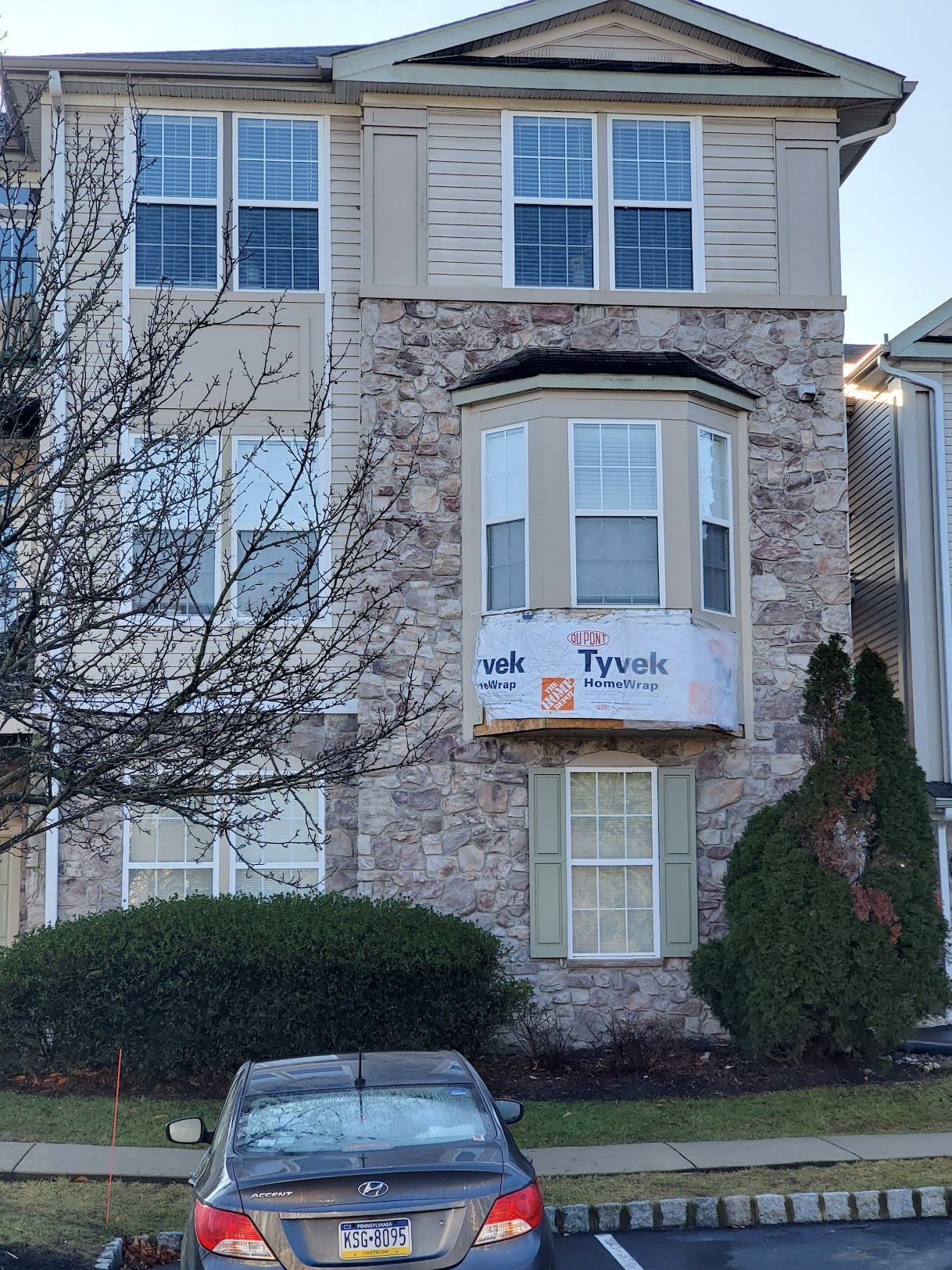 A car is parked in front of a large stone building.