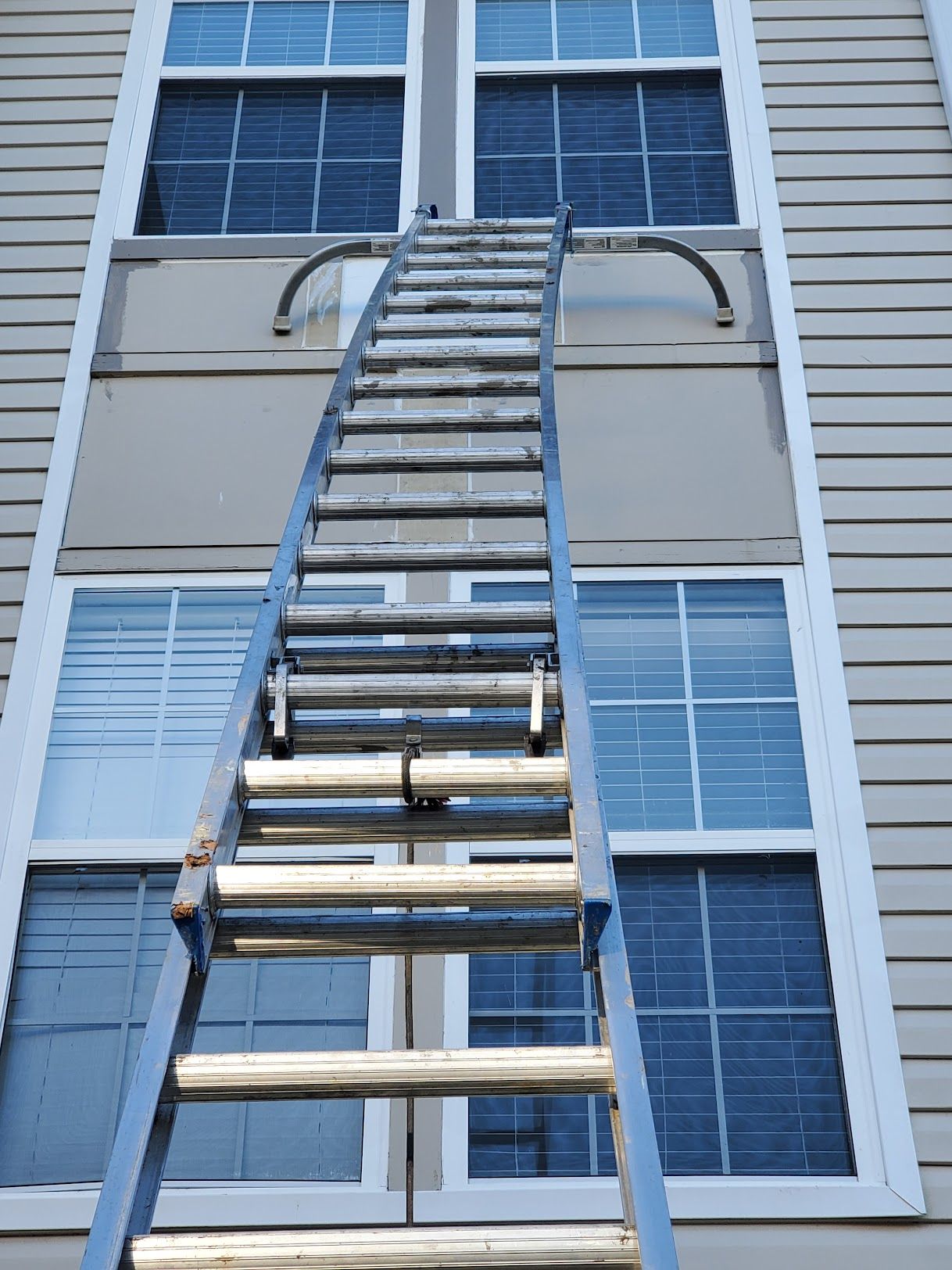 A ladder is going up the side of a building