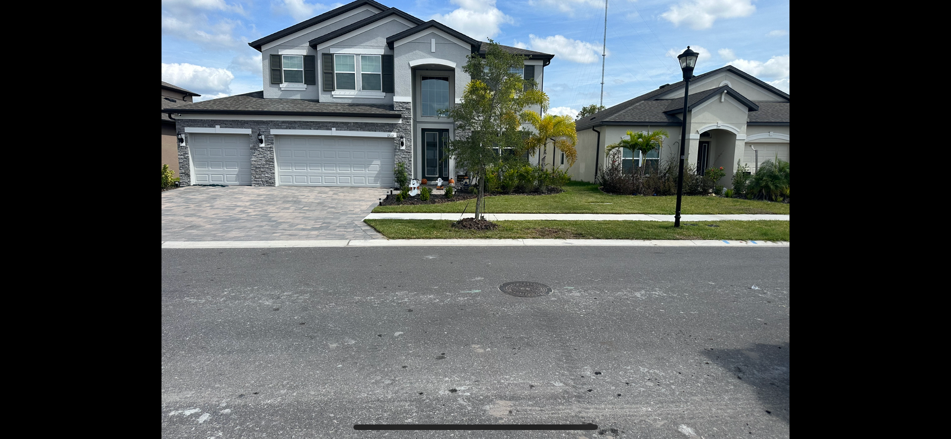 A large house is sitting on the side of the road next to a street.