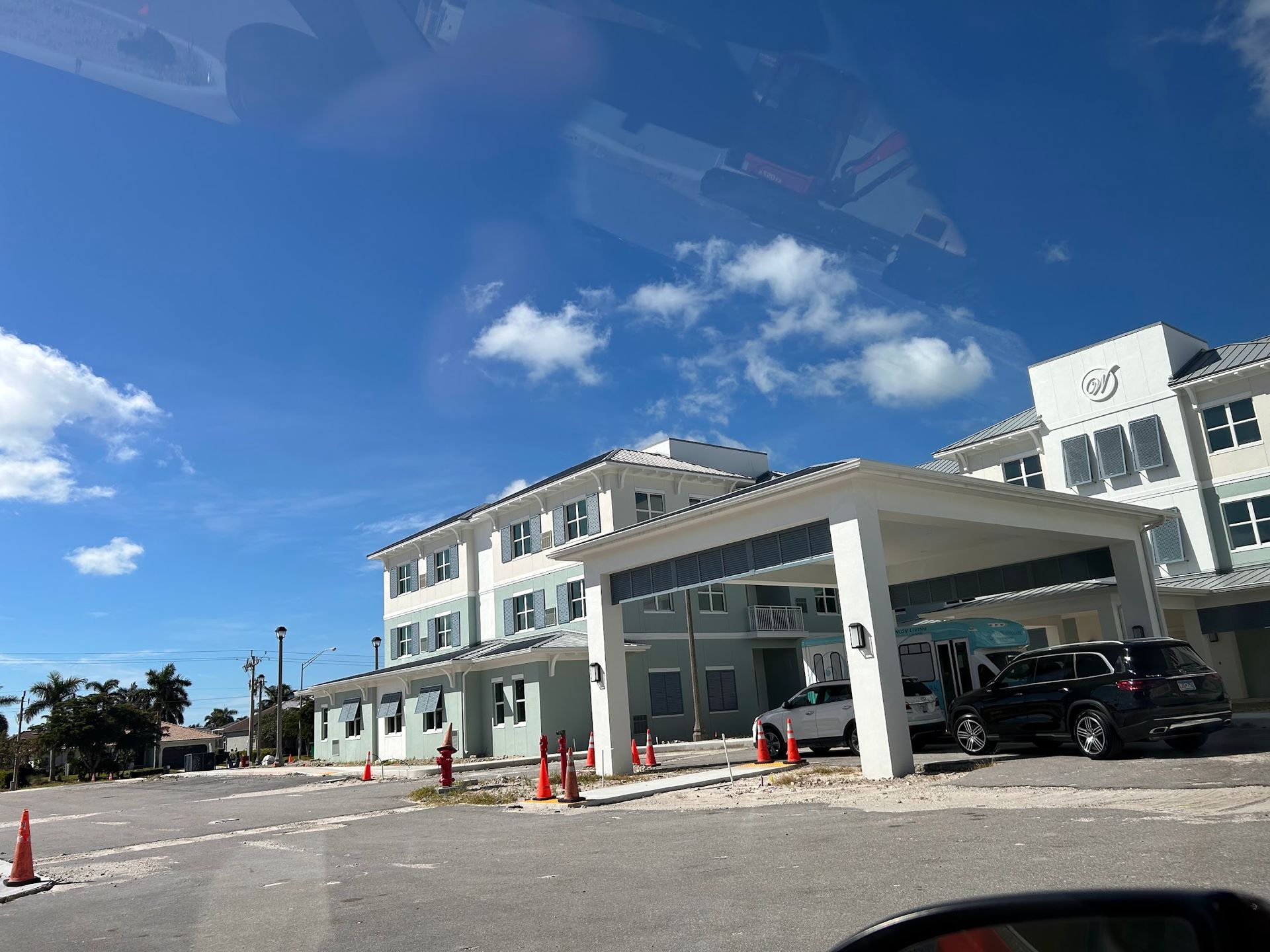 A large white building with cars parked in front of it