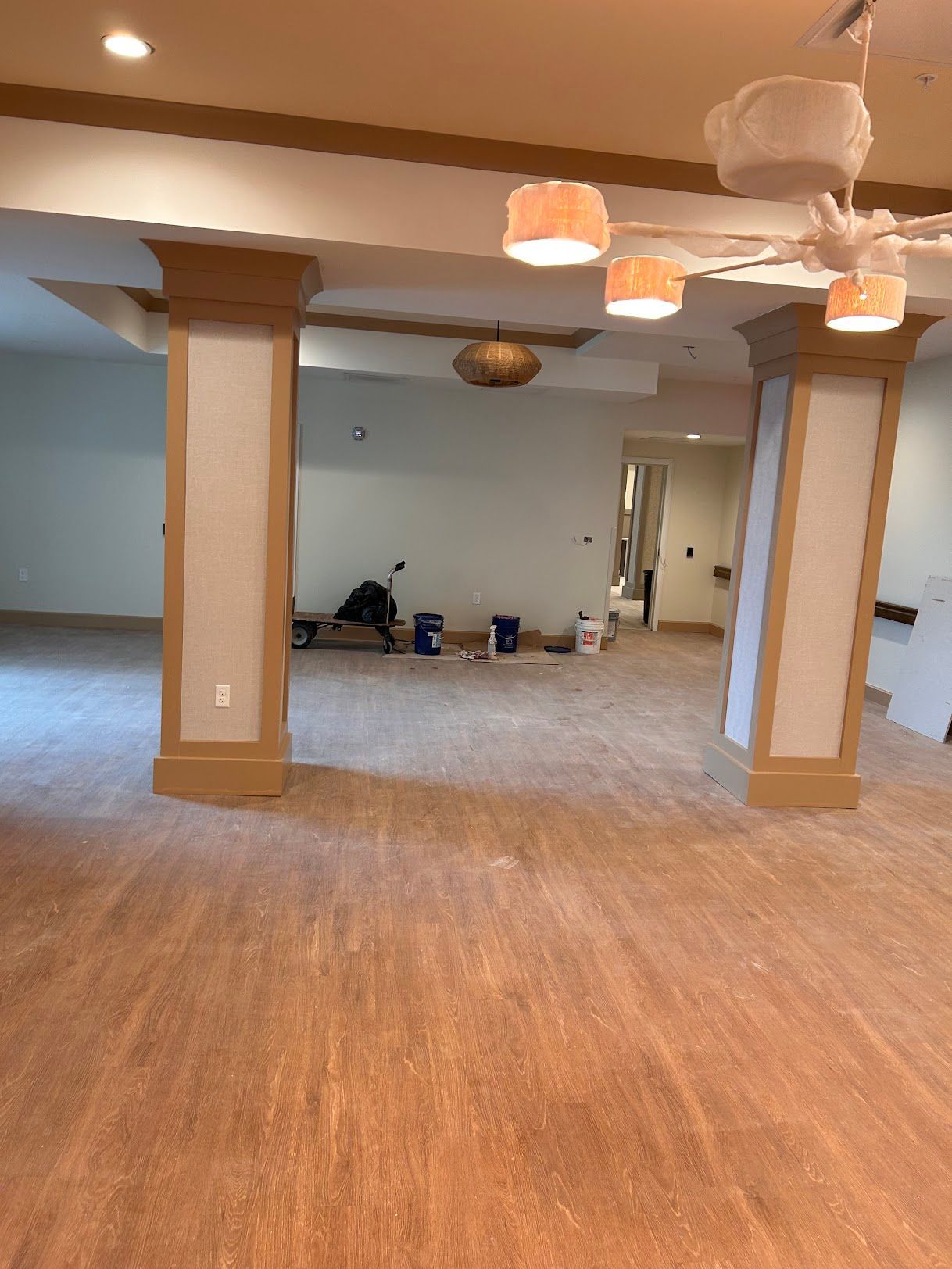 An empty room with a wooden floor and a ceiling fan.