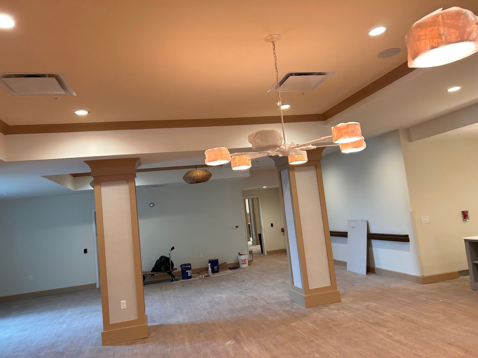 An empty room with a chandelier hanging from the ceiling.