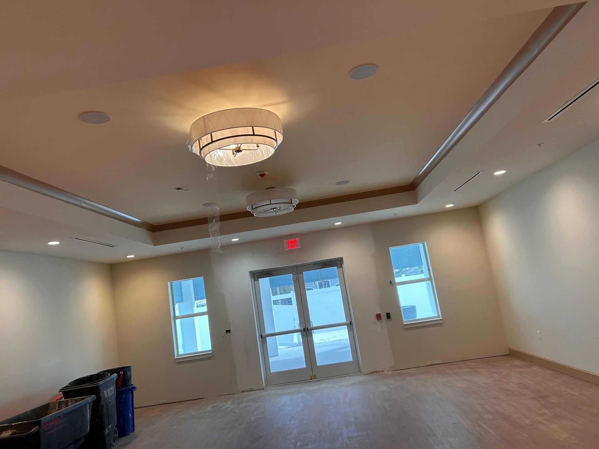 A large empty room with a chandelier hanging from the ceiling.