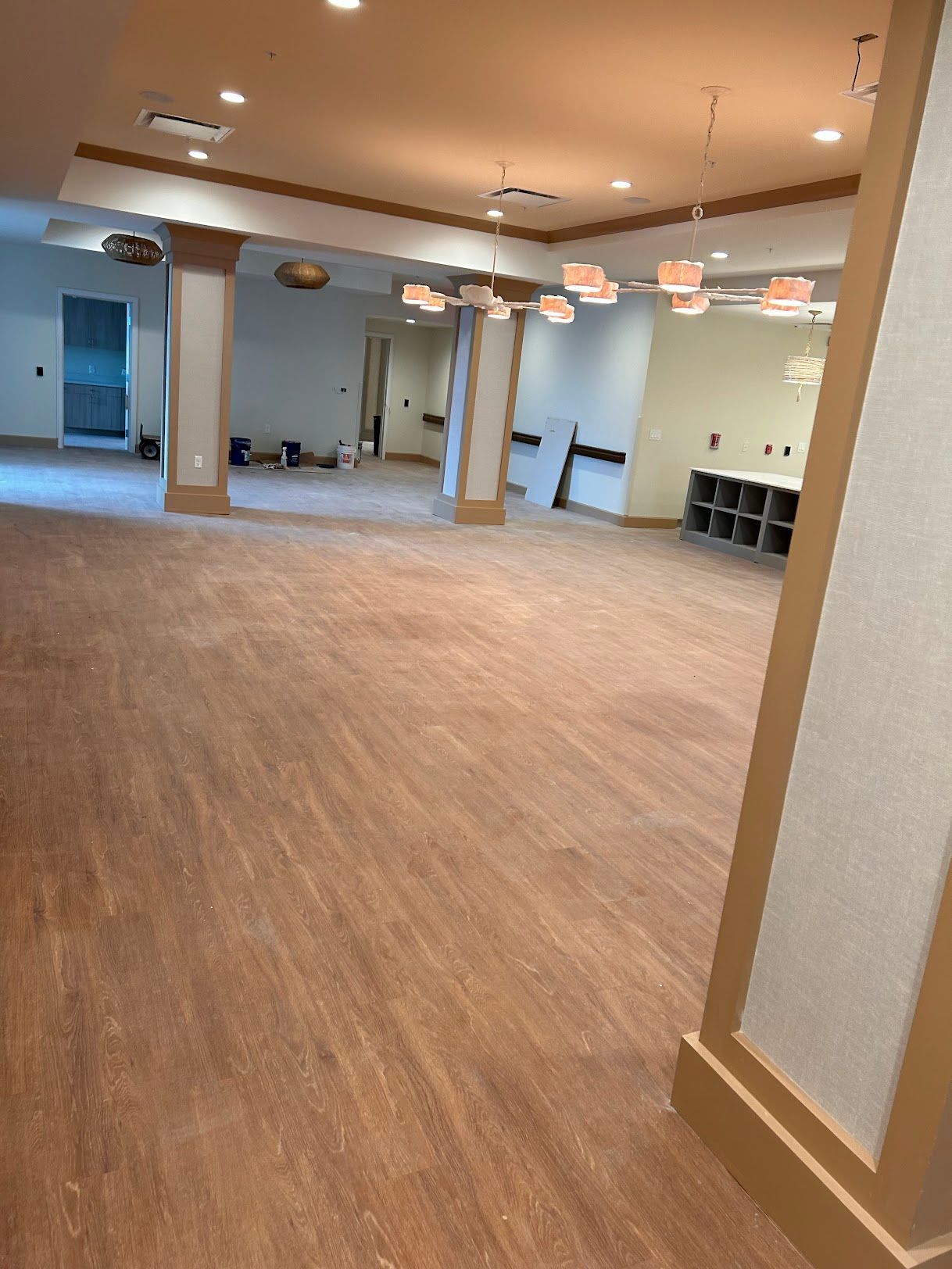 A large room with a wooden floor and columns