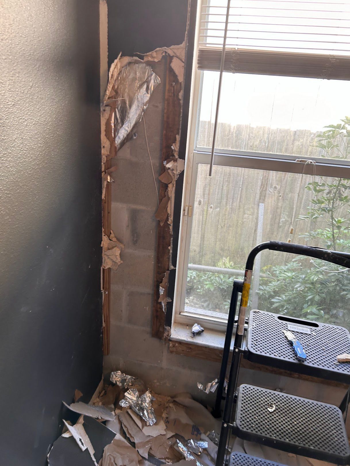 A room with a window and a ladder in it.