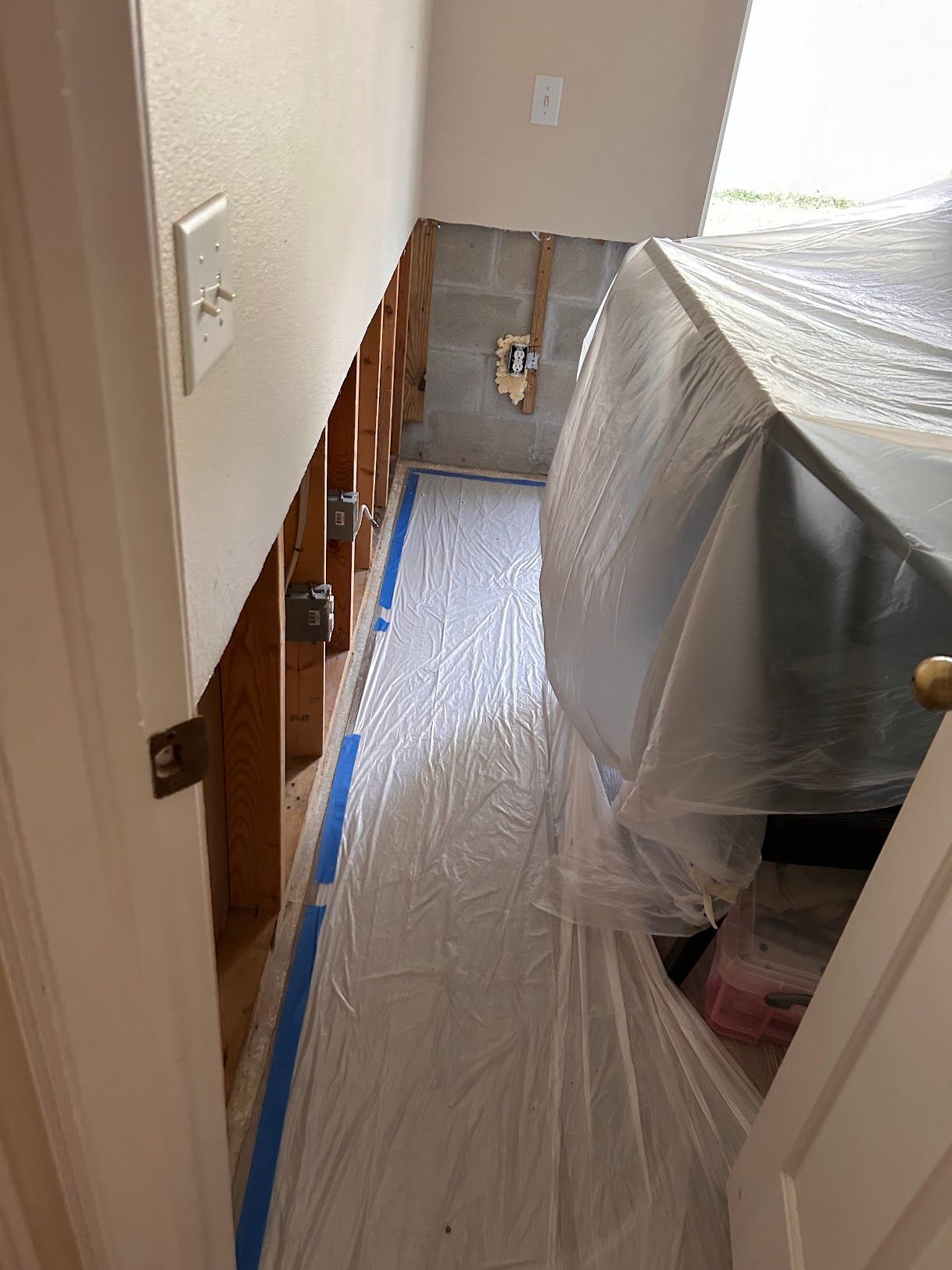 An empty dining room with hardwood floors and a wooden door.