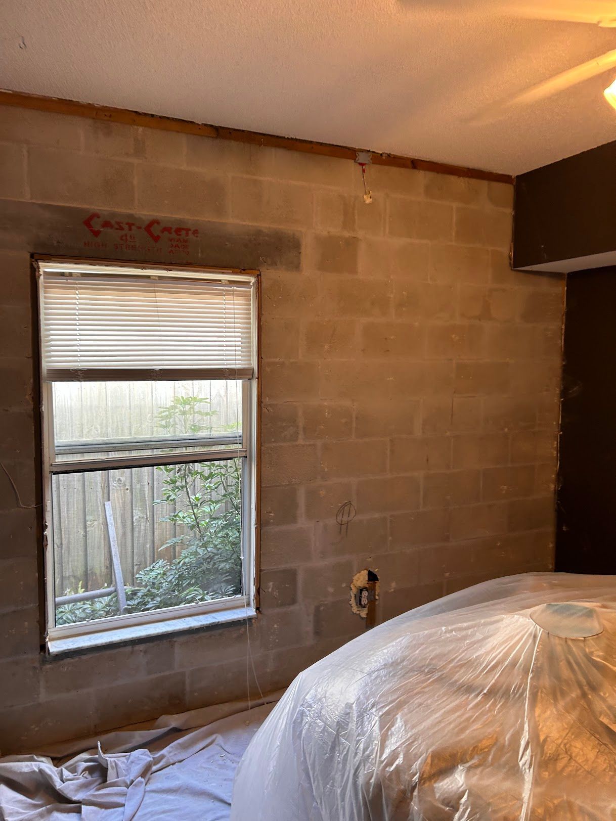 A bedroom with a brick wall and a window.