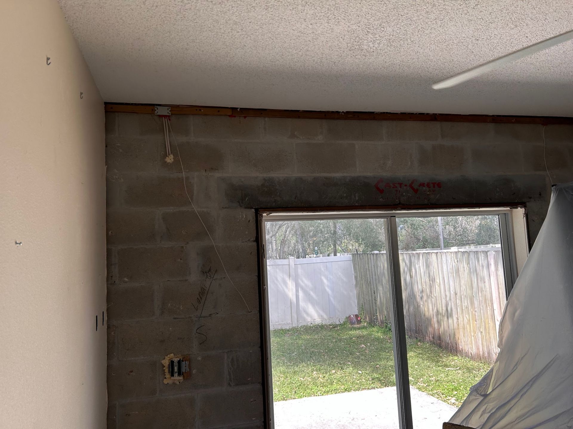 A room with a sliding glass door and a brick wall.