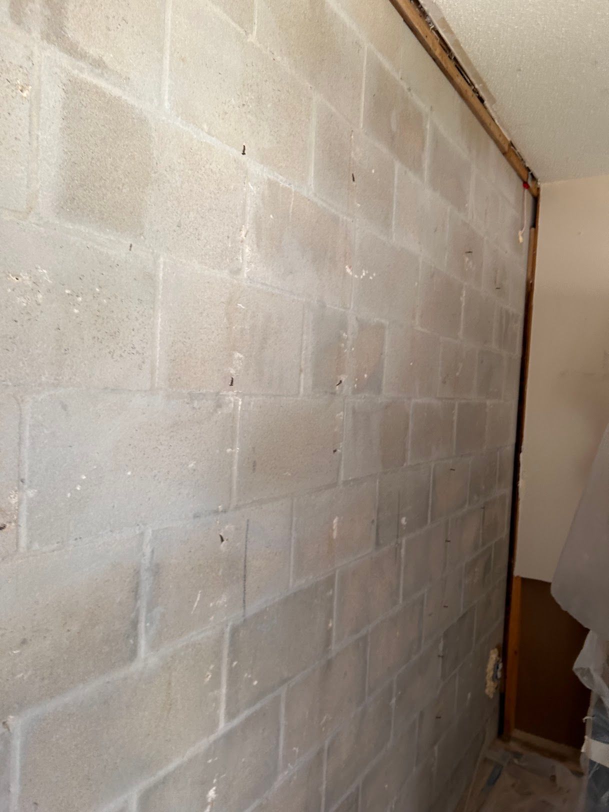 A white brick wall in a room with a wooden trim