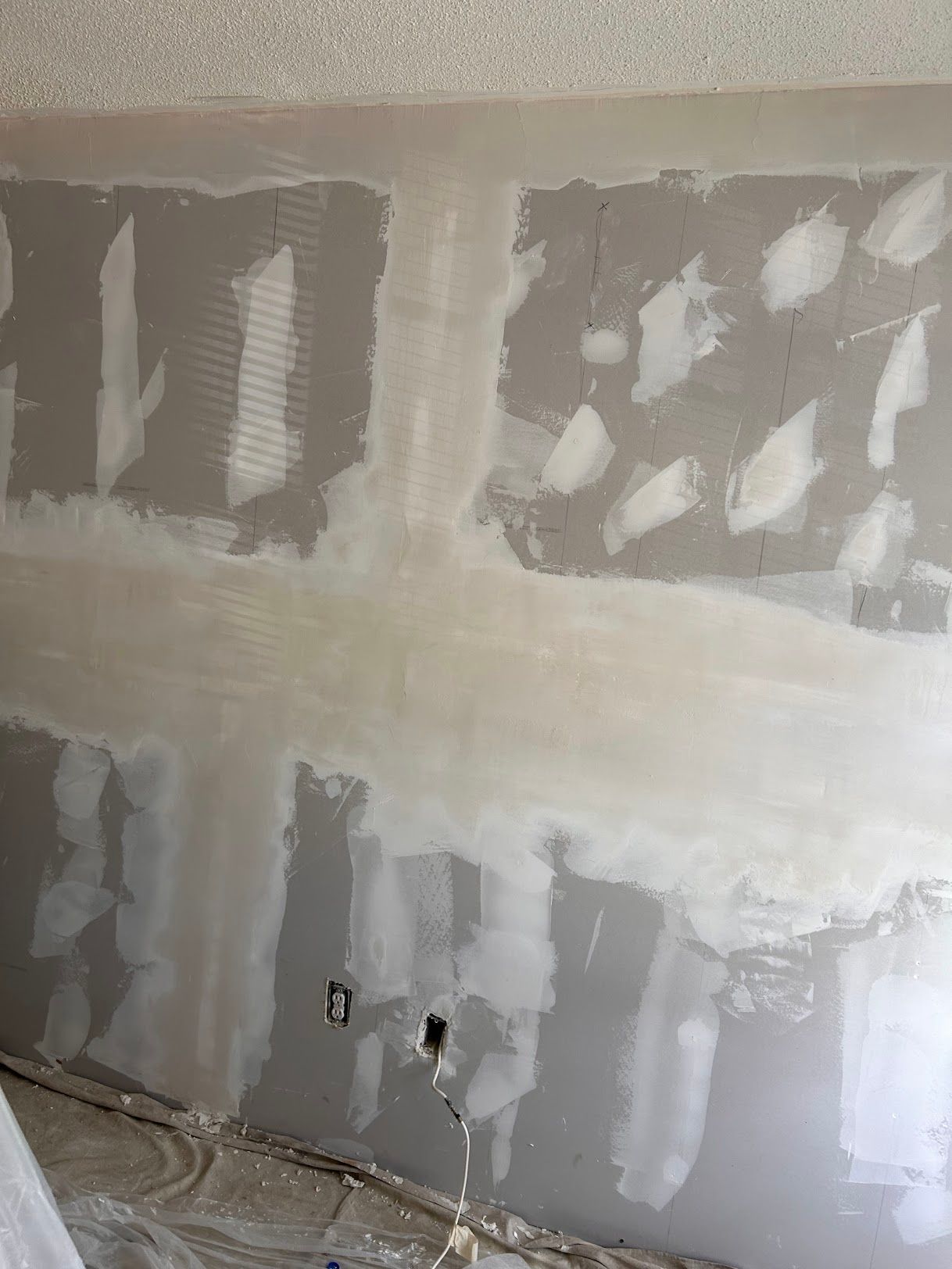 A wall is being plastered in a room.