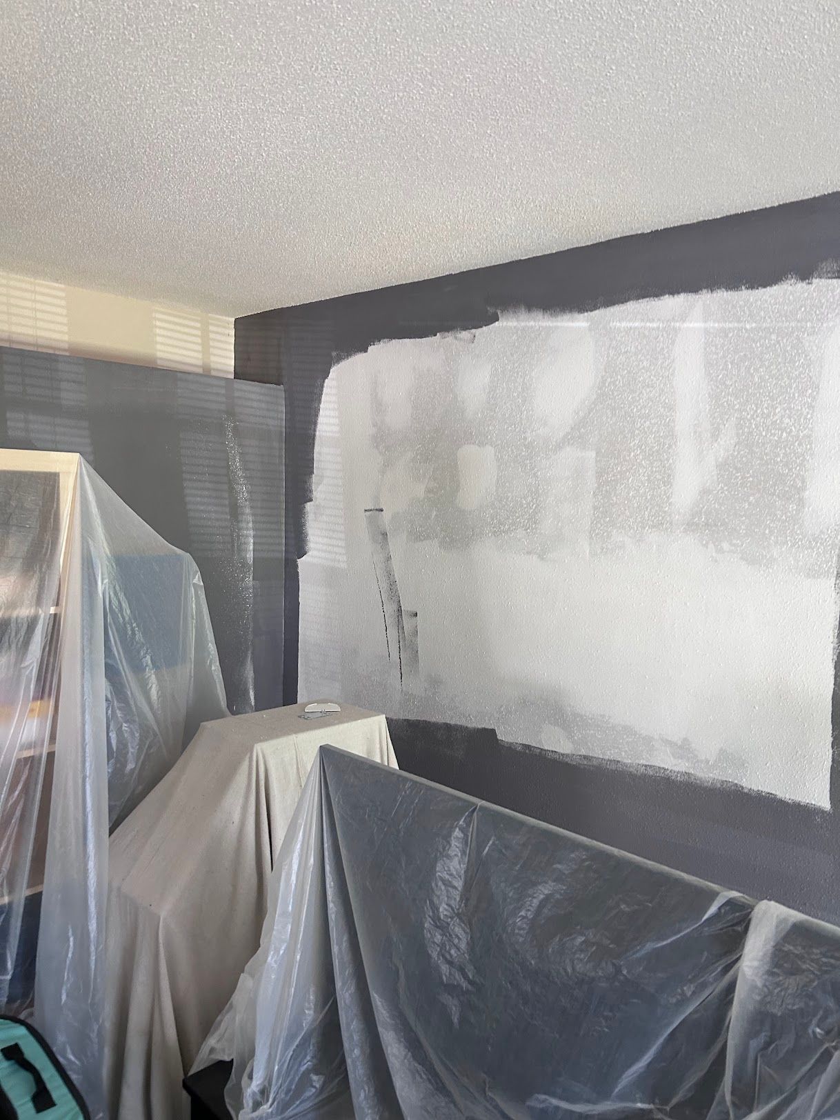 A room is being painted and covered in plastic.