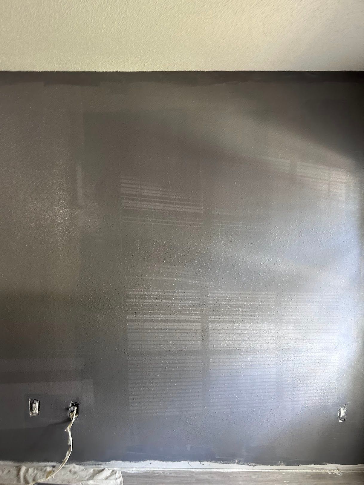 A room with a gray wall and a window.