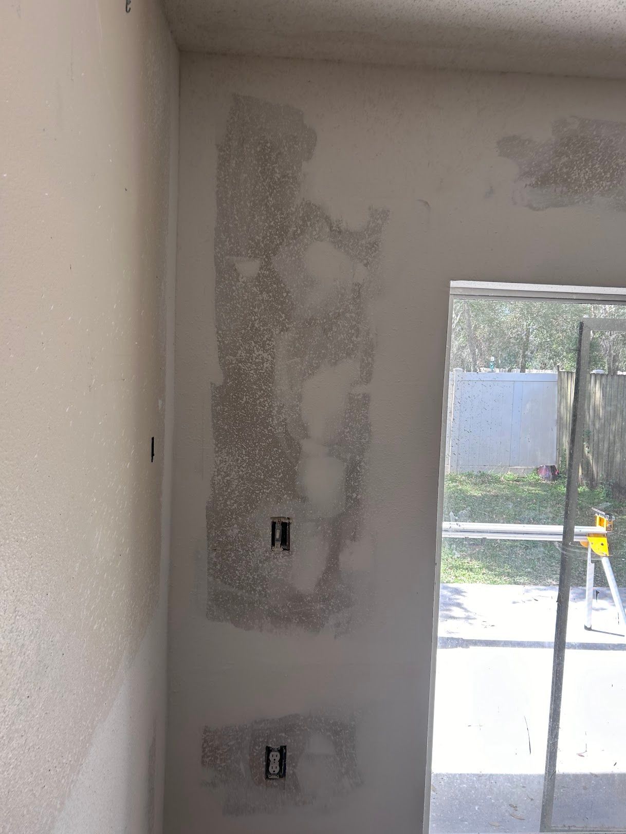 A room with a sliding glass door and a white wall.