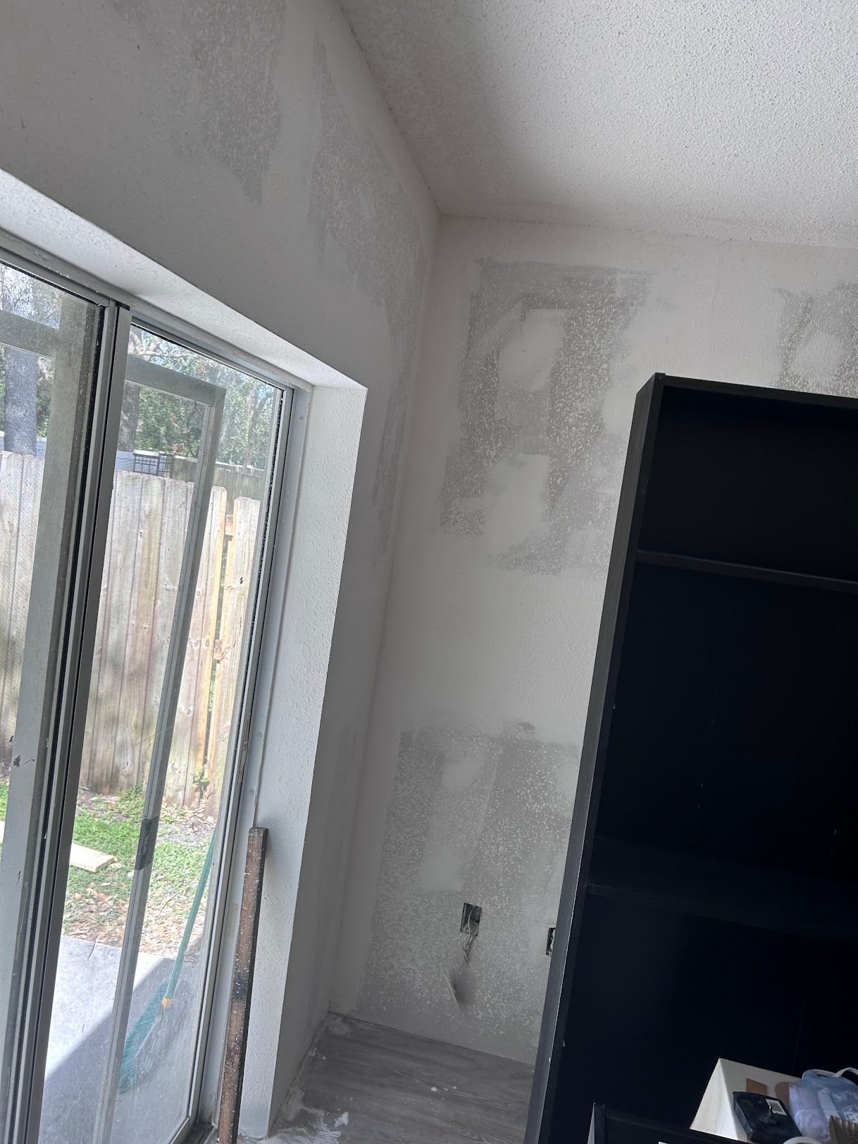 A room with a lot of windows and a shelf in it.