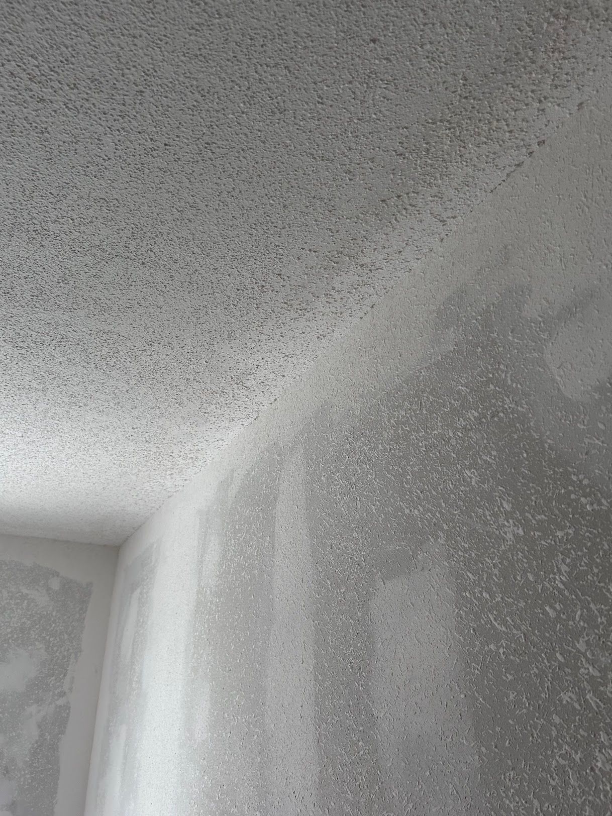 A corner of a room with a ceiling that has a lot of holes in it.