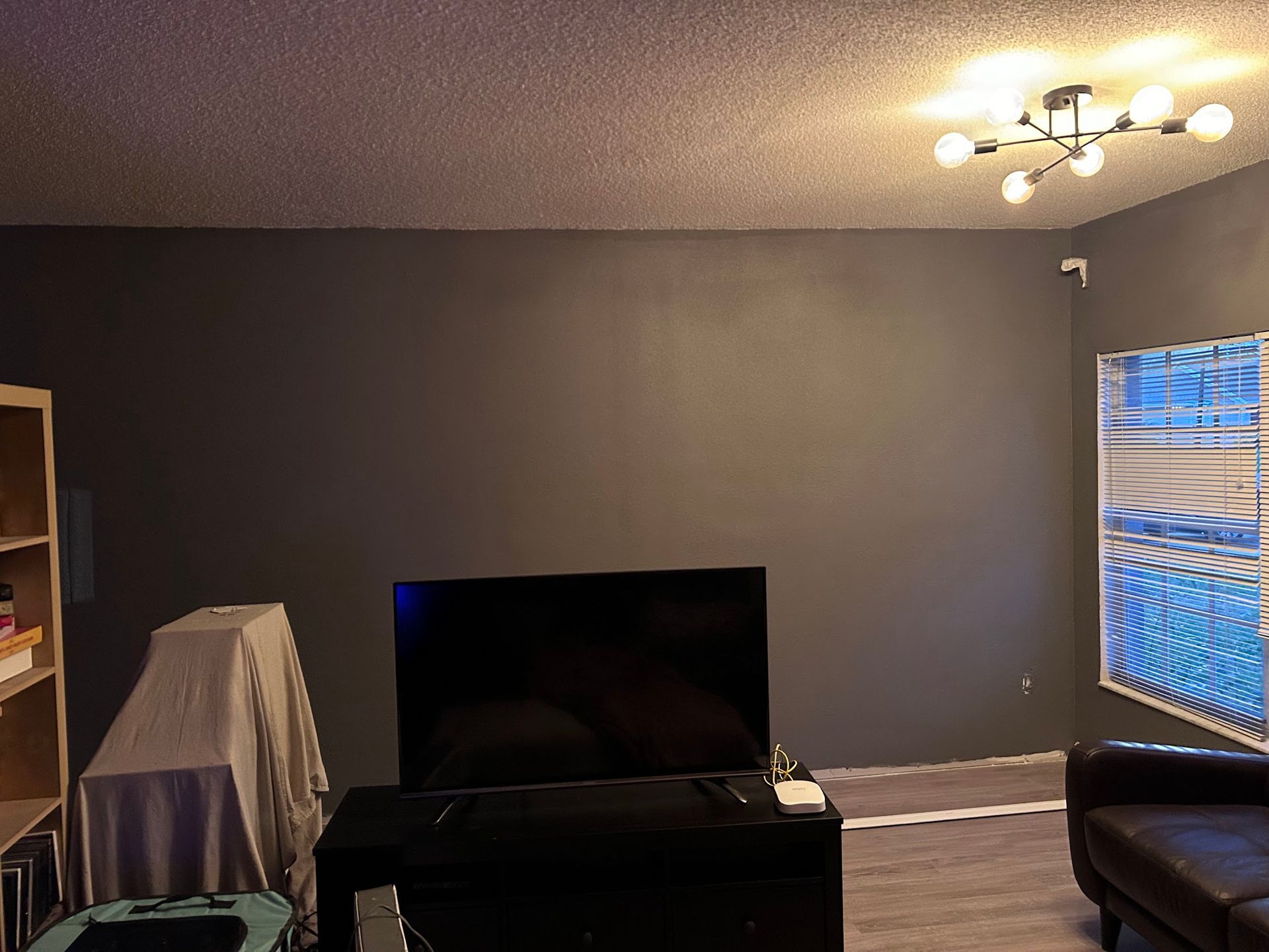 A living room with a flat screen tv and a couch.