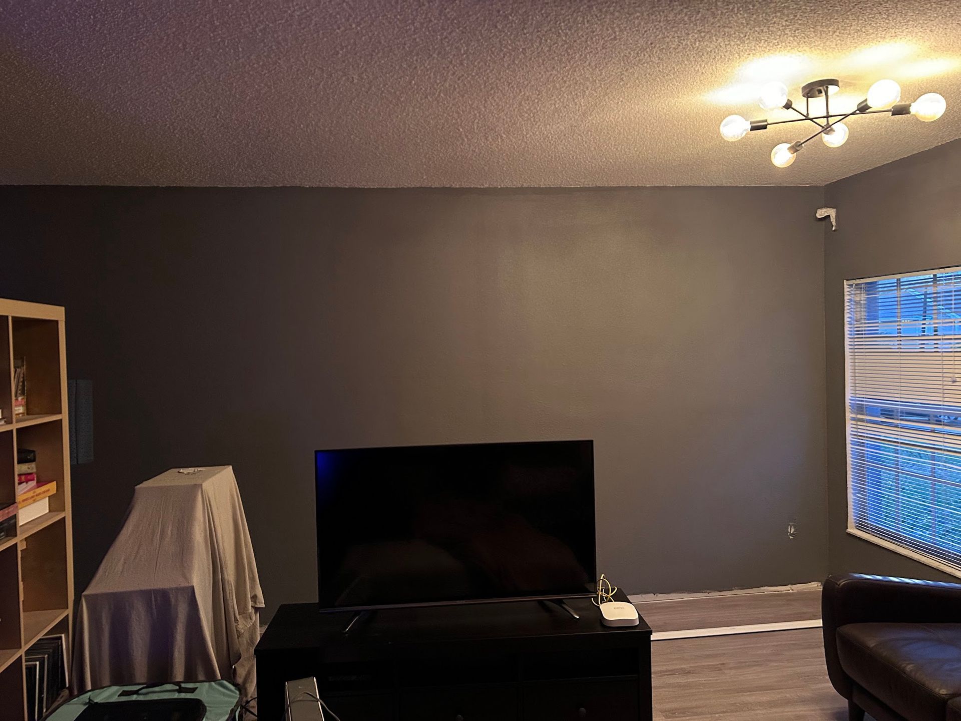 A living room with a flat screen tv and a couch.