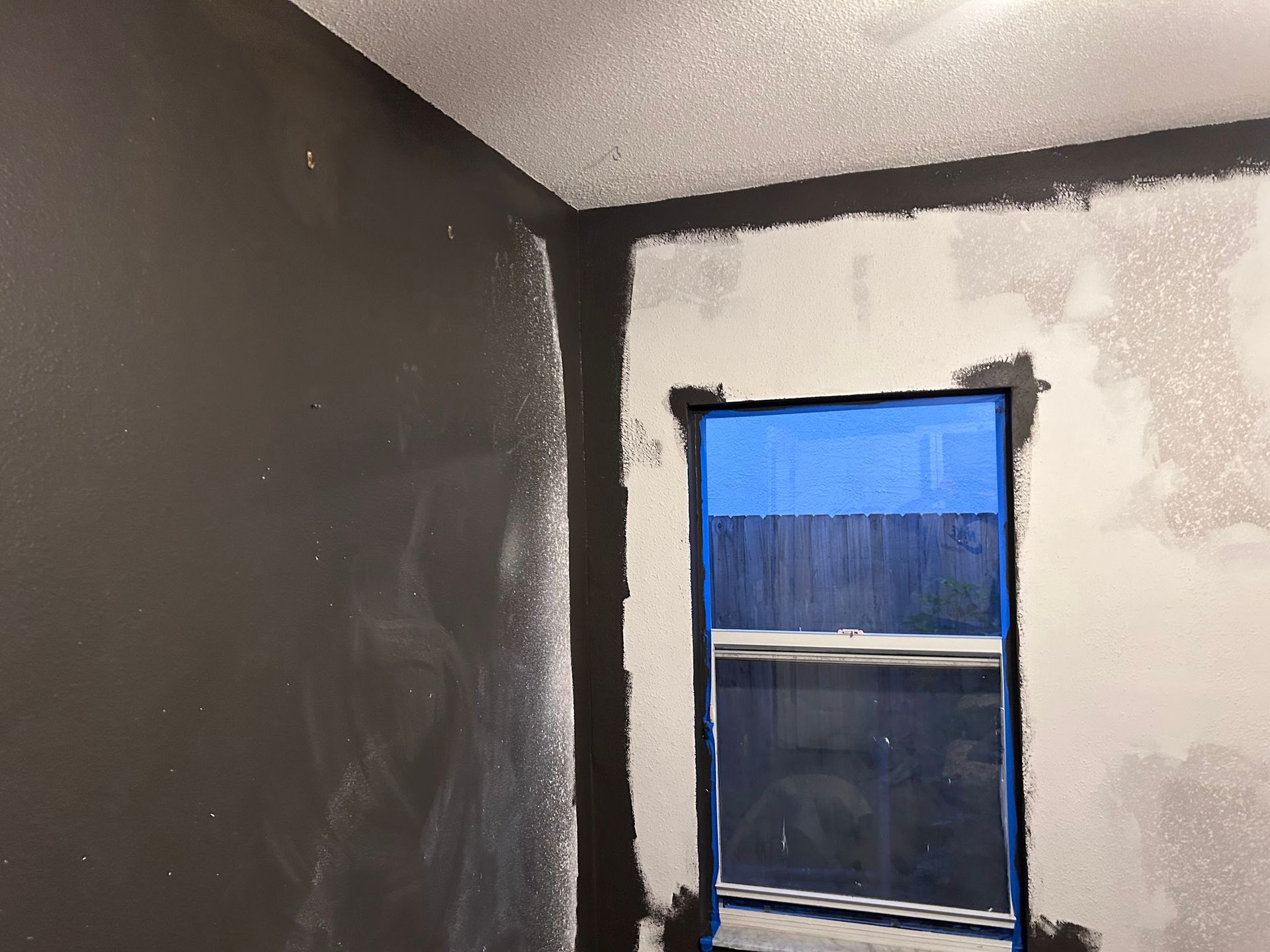 A room with a window being painted black and white
