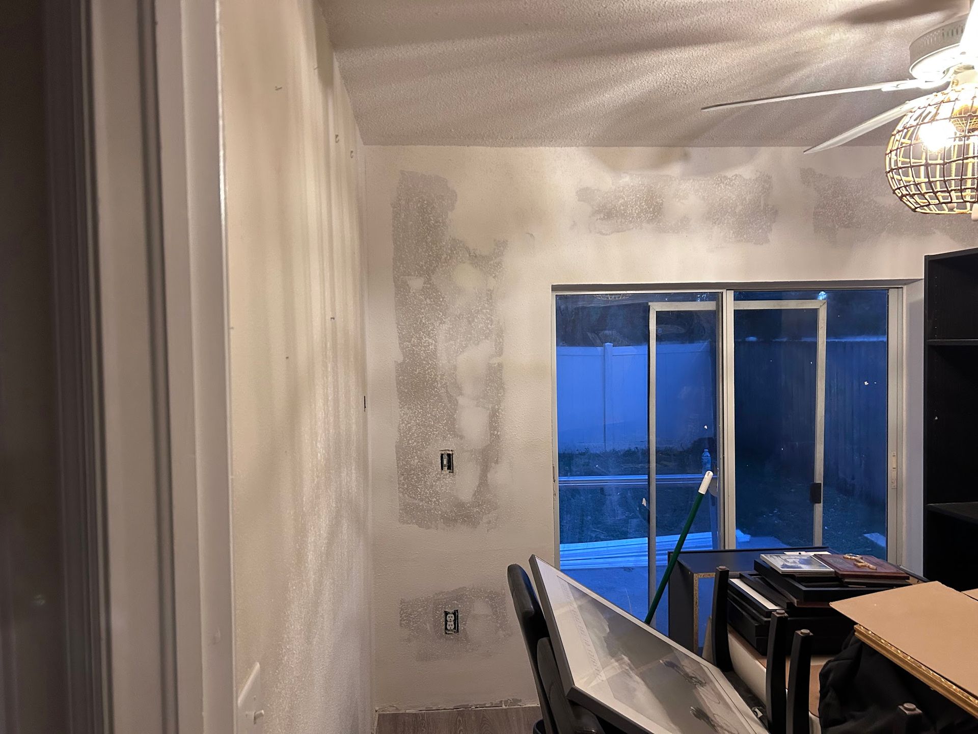 A living room with a ceiling fan and a sliding glass door.