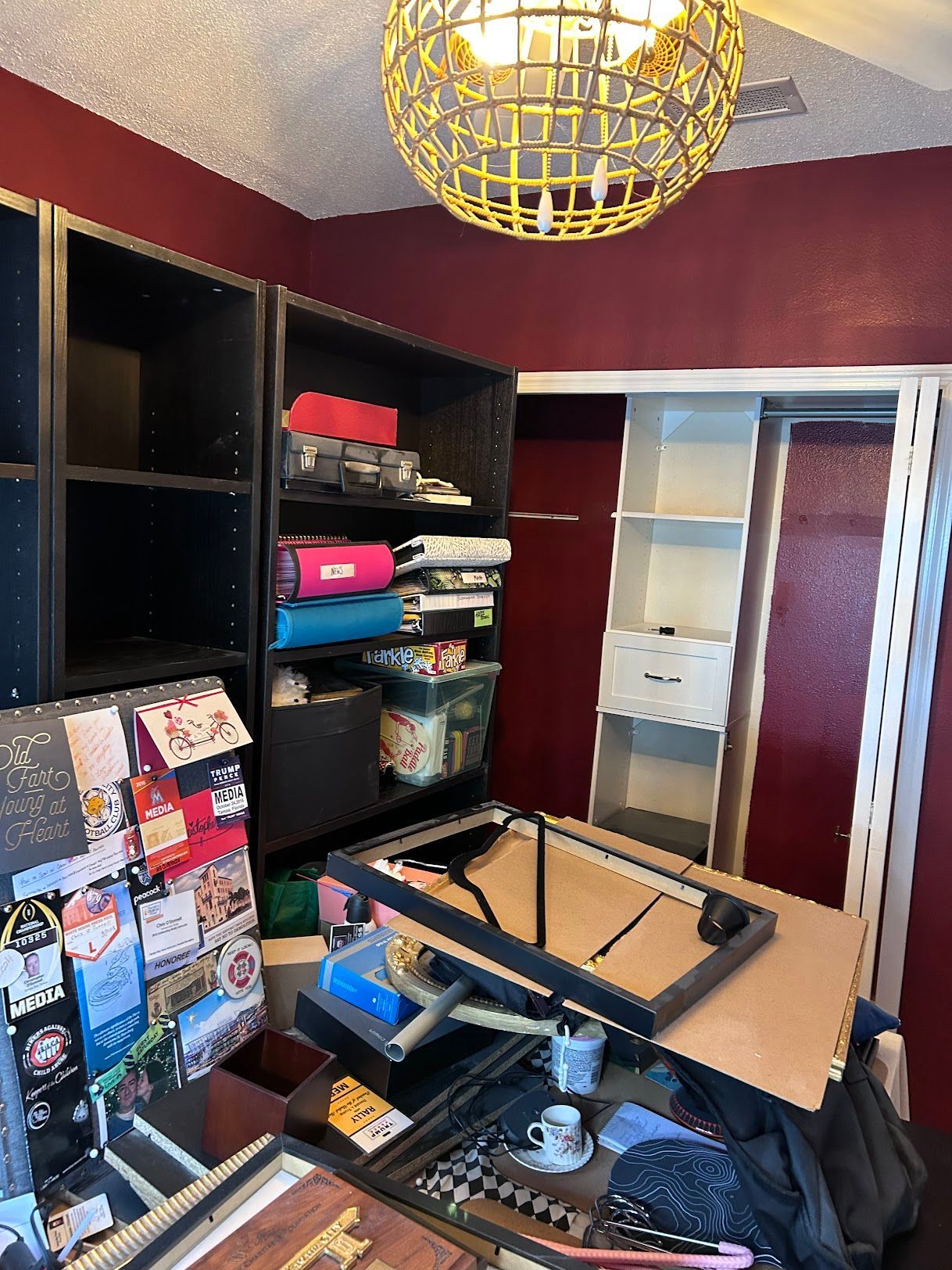 A room with a lot of shelves and a chandelier hanging from the ceiling.