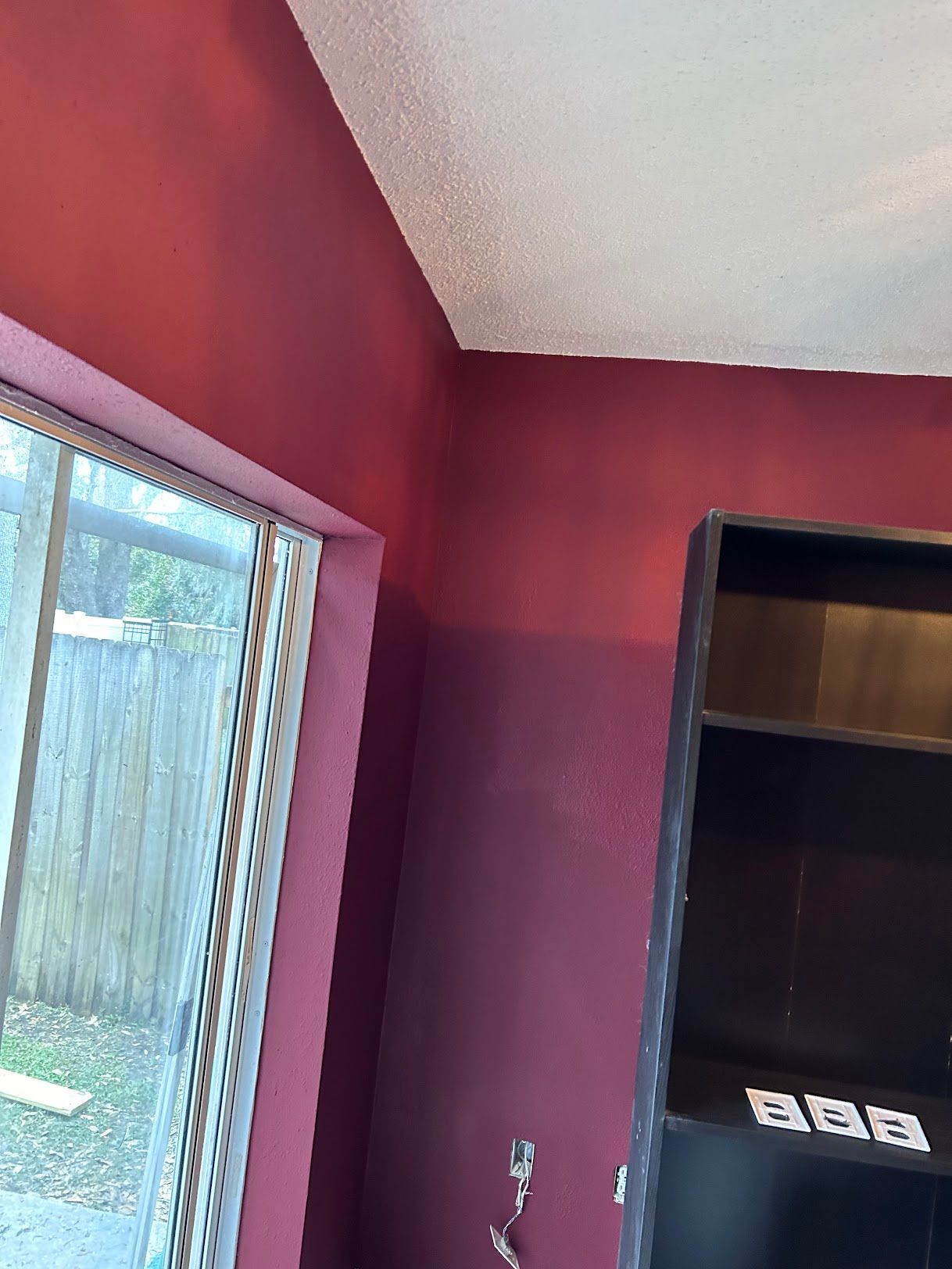 A room with red walls and a black shelf
