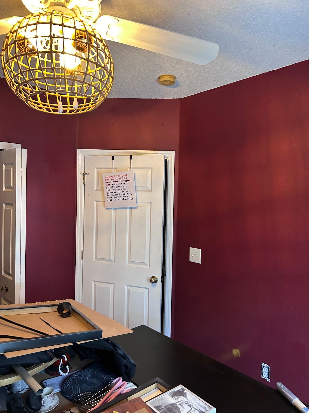 A room with red walls and a ceiling fan