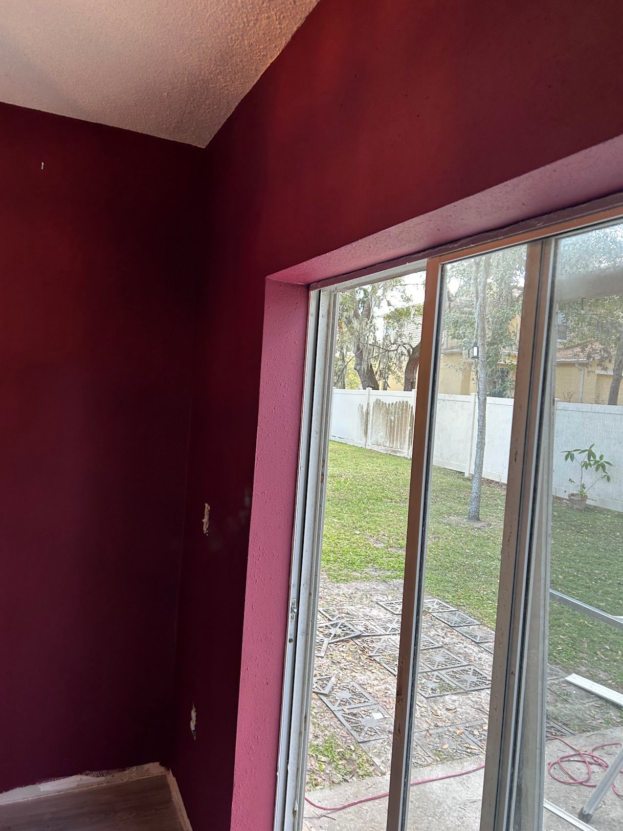A room with red walls and a sliding glass door.