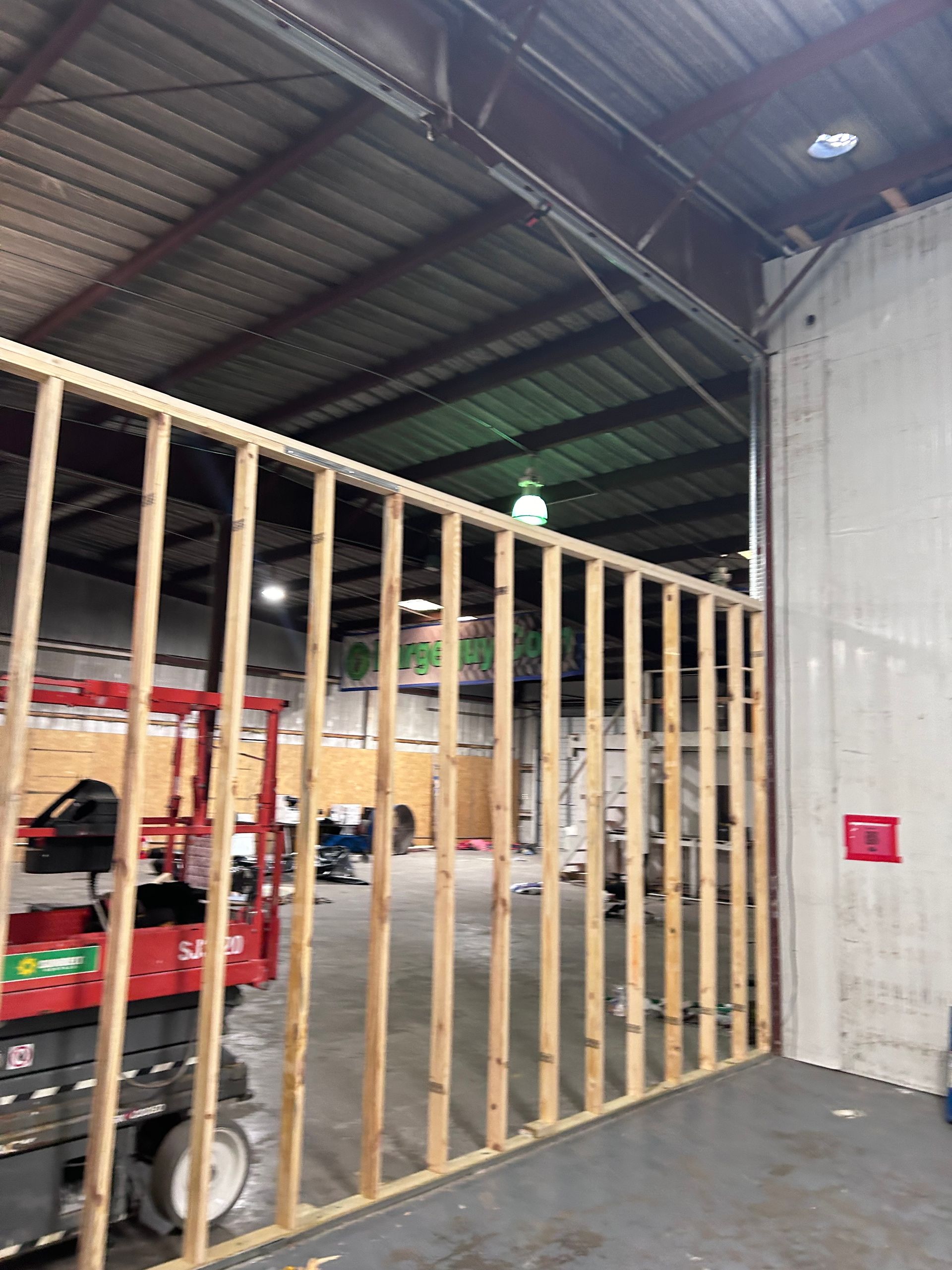 A wooden wall is being built in a warehouse.