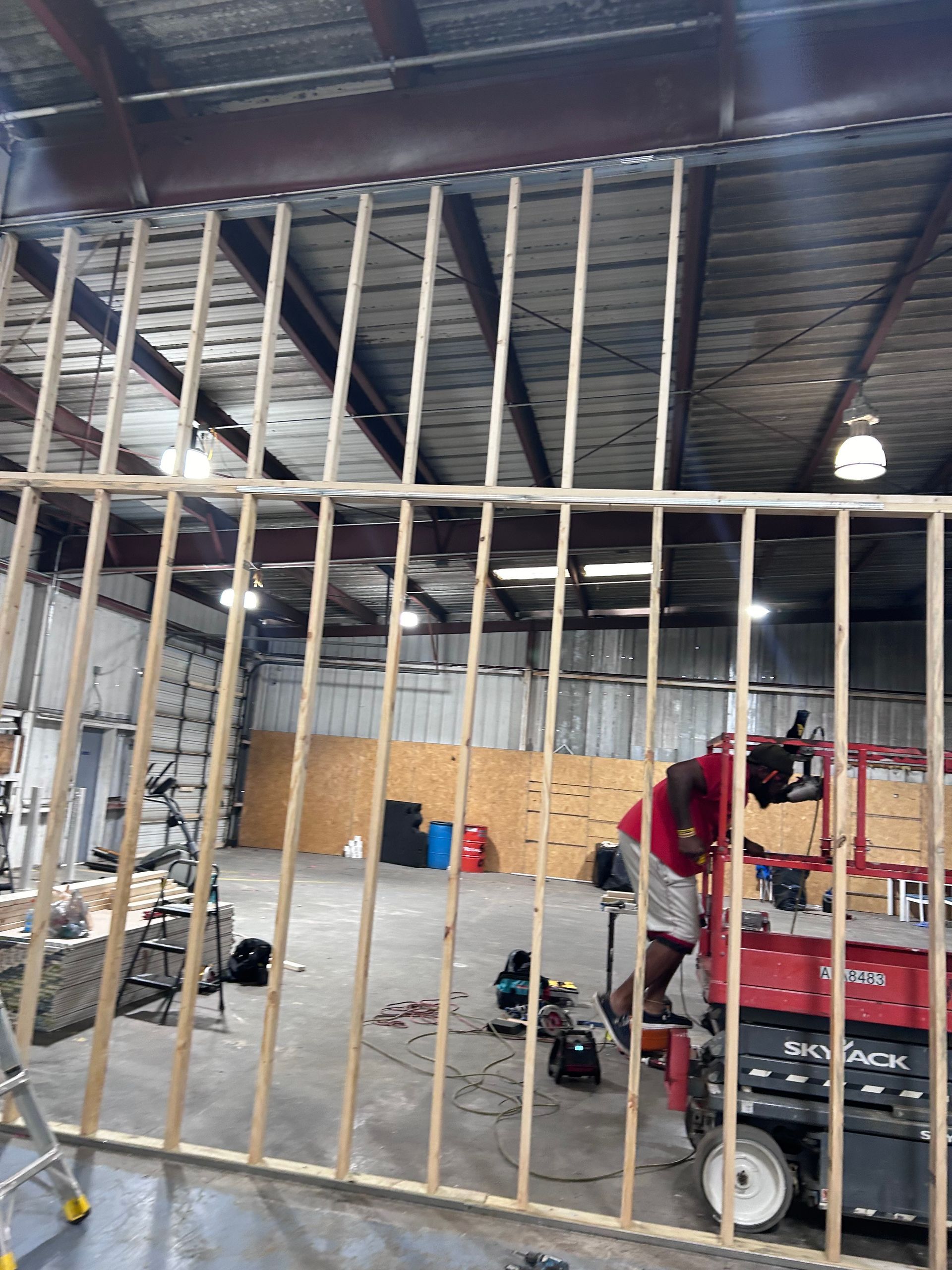 A man is working on a wall in a warehouse