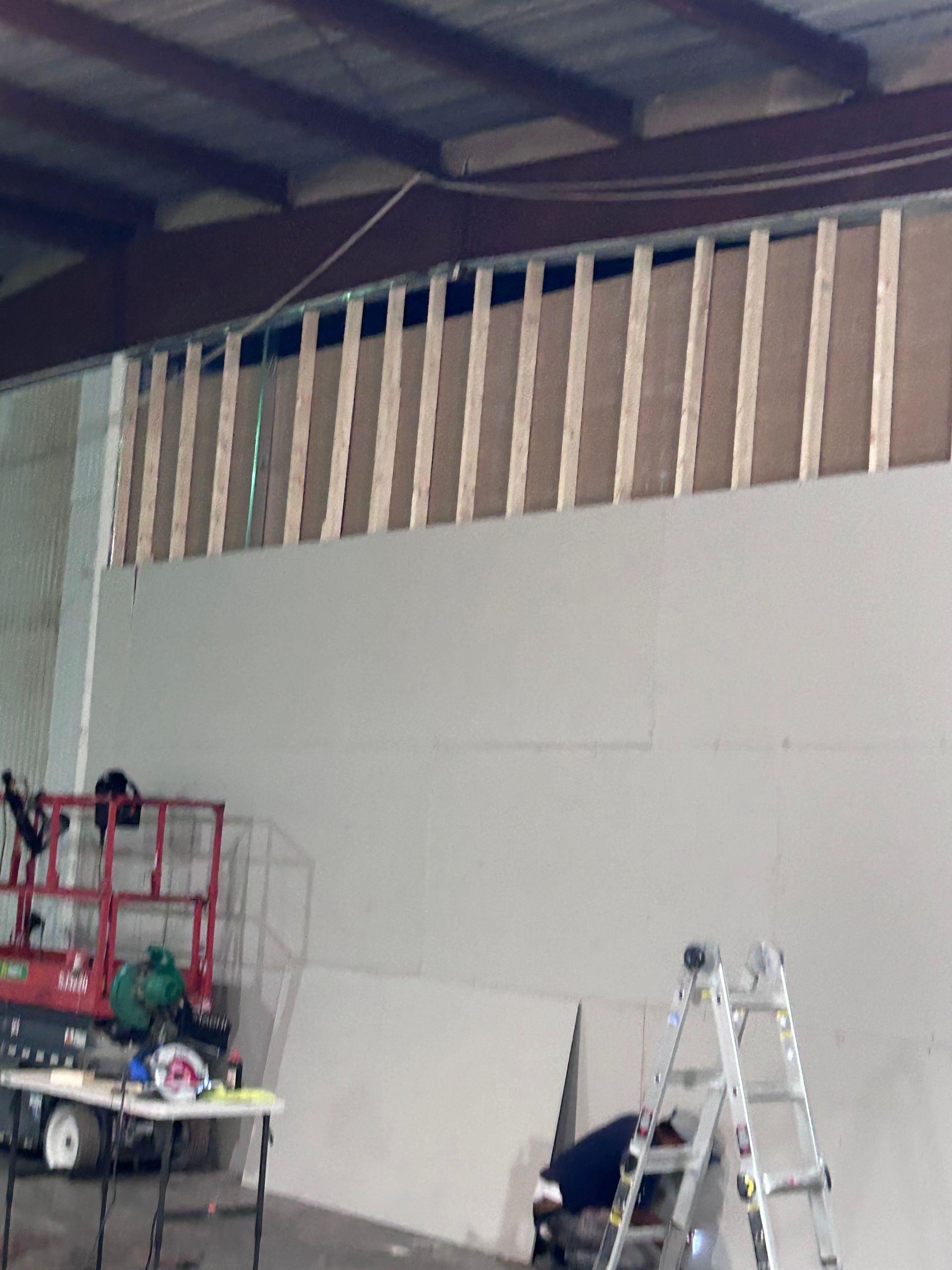 A white wall with a ladder in front of it